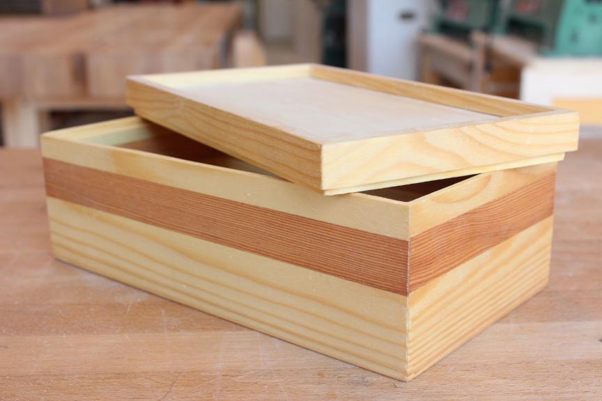 Finished mitred box with lid resting askewed on top of box body