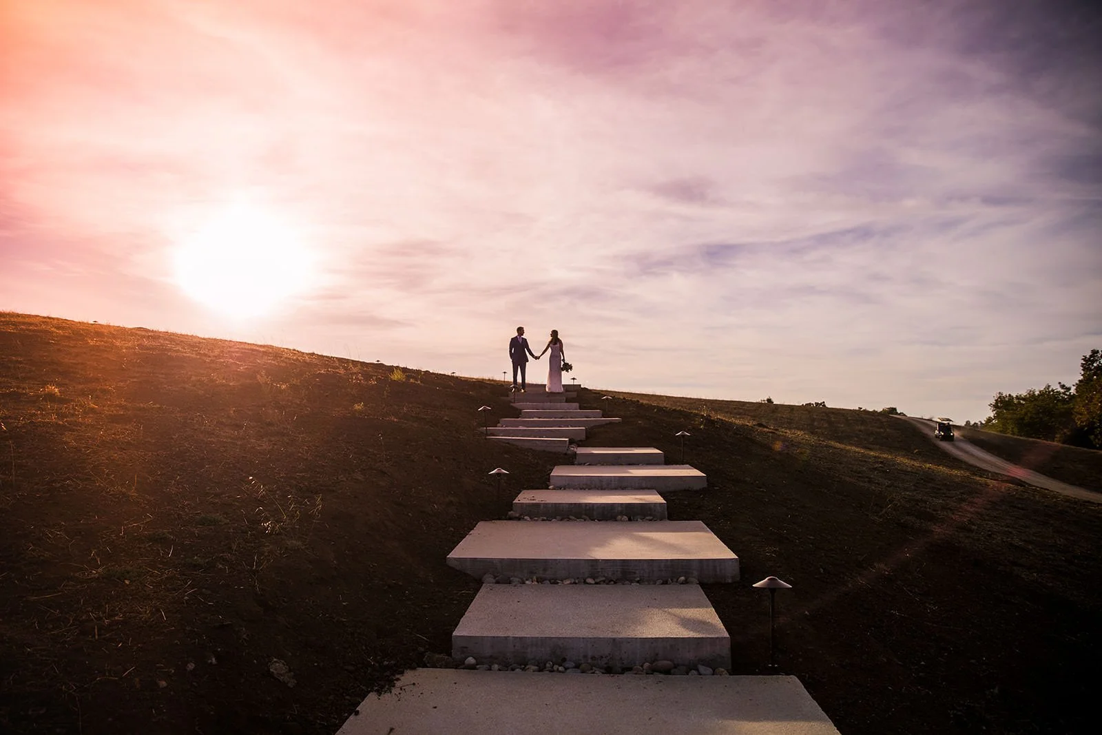 Bride and groom silhouette on Flying Caballos Ranch hilltop staircase at sunset, San Luis Obispo wedding photography by Michael Stephens