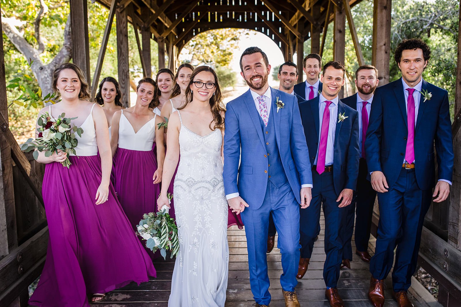 Wedding party walking through covered wooden bridge at Flying Caballos Ranch, San Luis Obispo