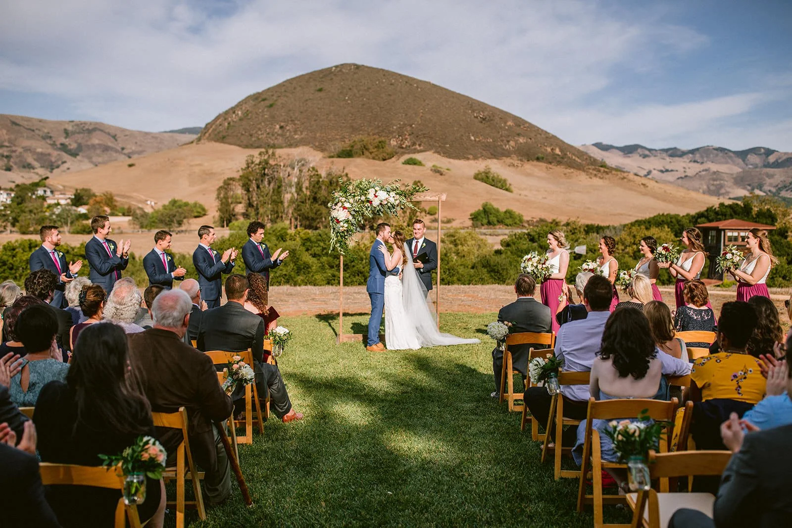 First kiss at Flying Caballos Ranch outdoor wedding ceremony with Islay Hill in background, Edna Valley wedding photography