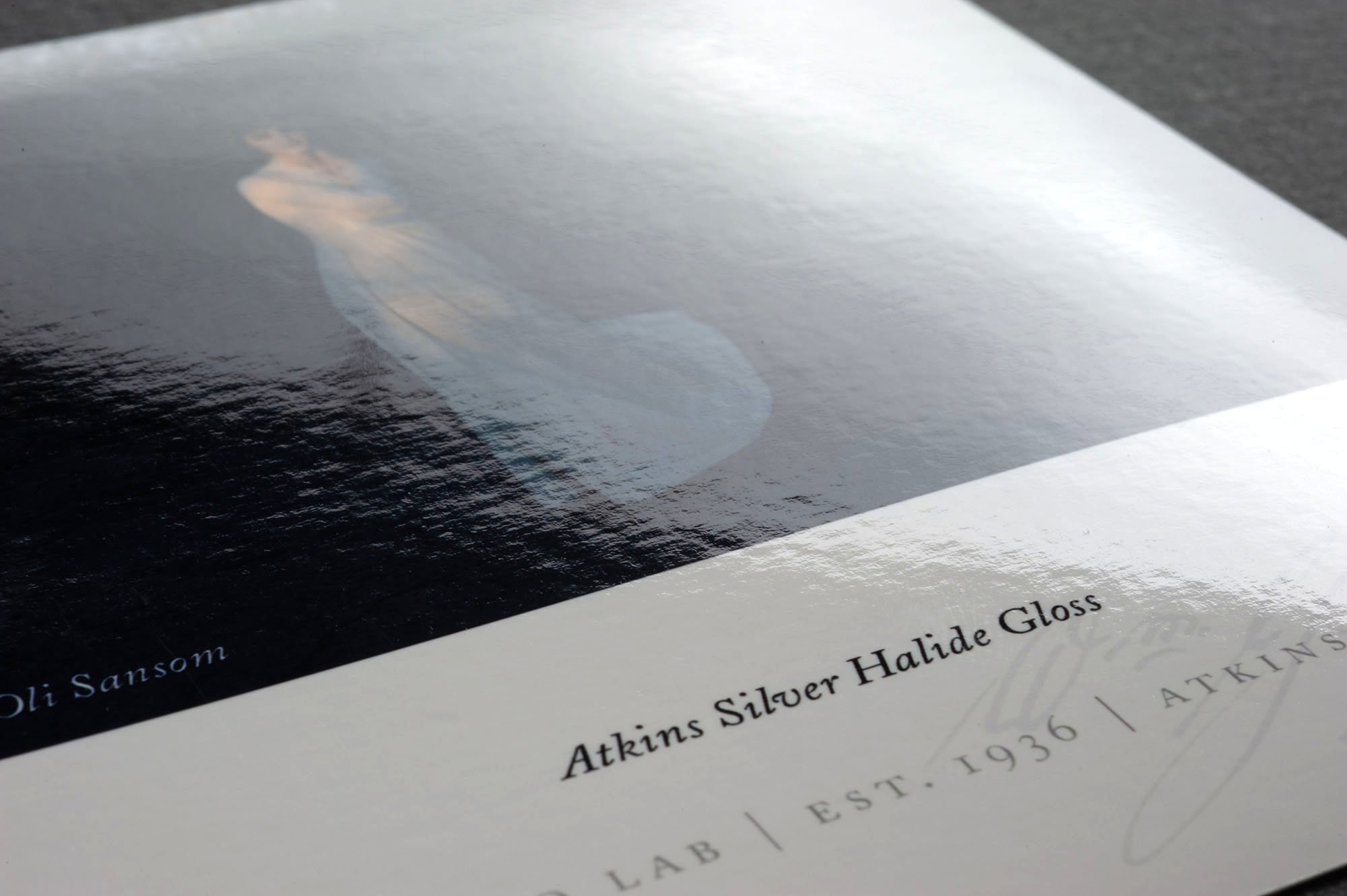 A booklet titled 'Atkins Silver Halide Gloss' with a partial image of a person on the cover, placed on a dark surface.