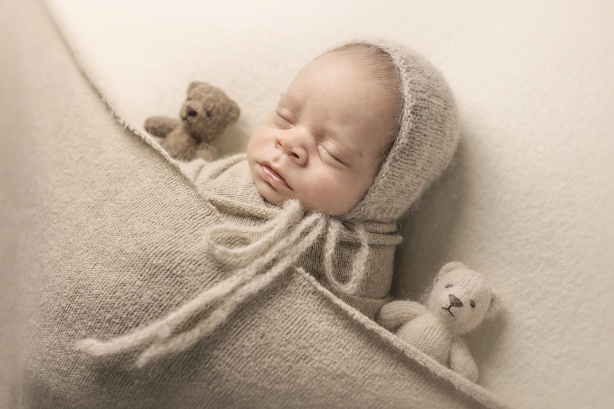 wrapped baby asleep with bonnet teddy bears, newborn photography penrith mini session