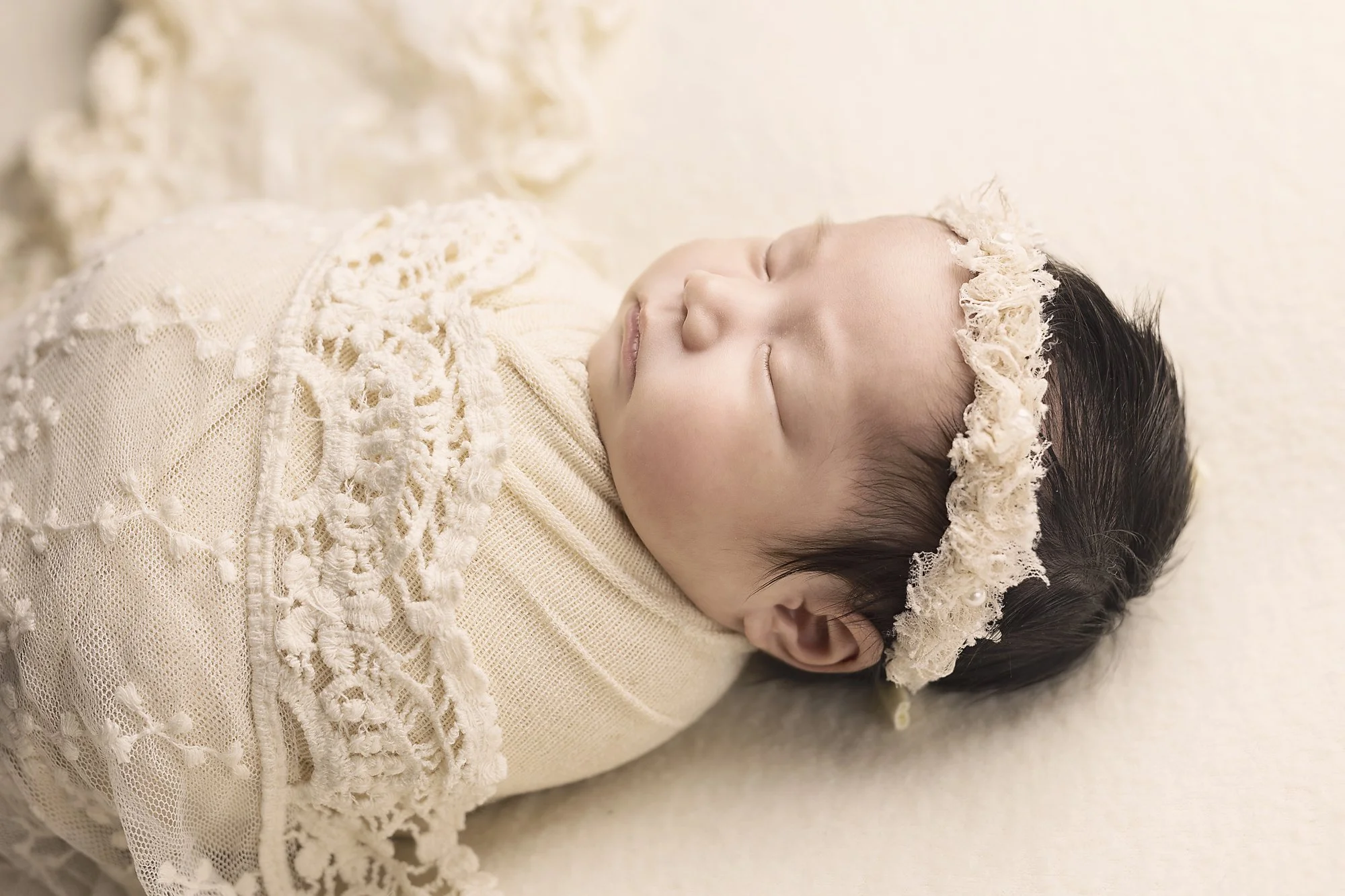 newborn baby girl photographed asleep in cream and lace wrapped penrith blue mountains hills district western sydney mini session