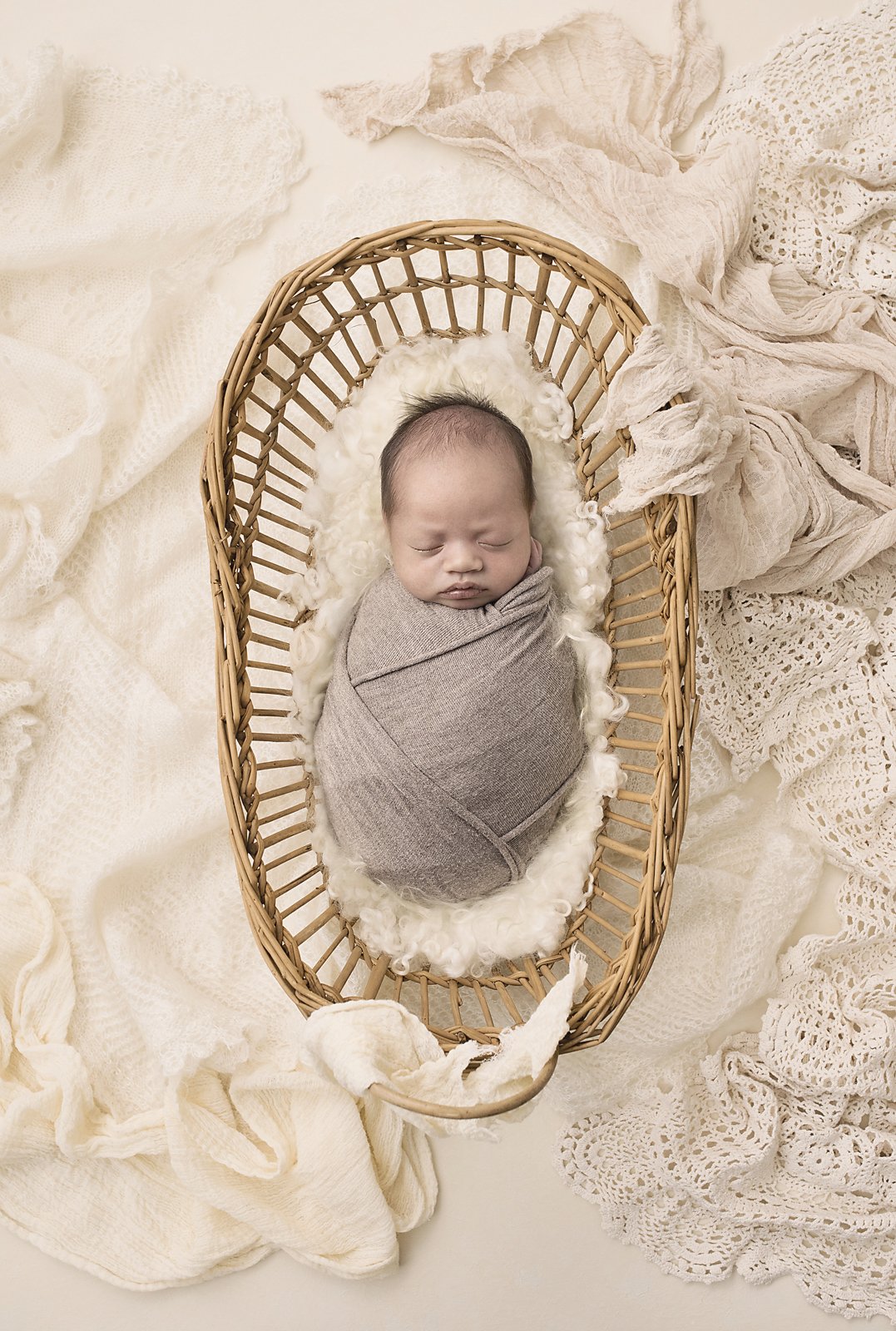 newborn baby boy wrapped and asleep in moses basket cream surrounds penrith blue mountains western sydney hills district