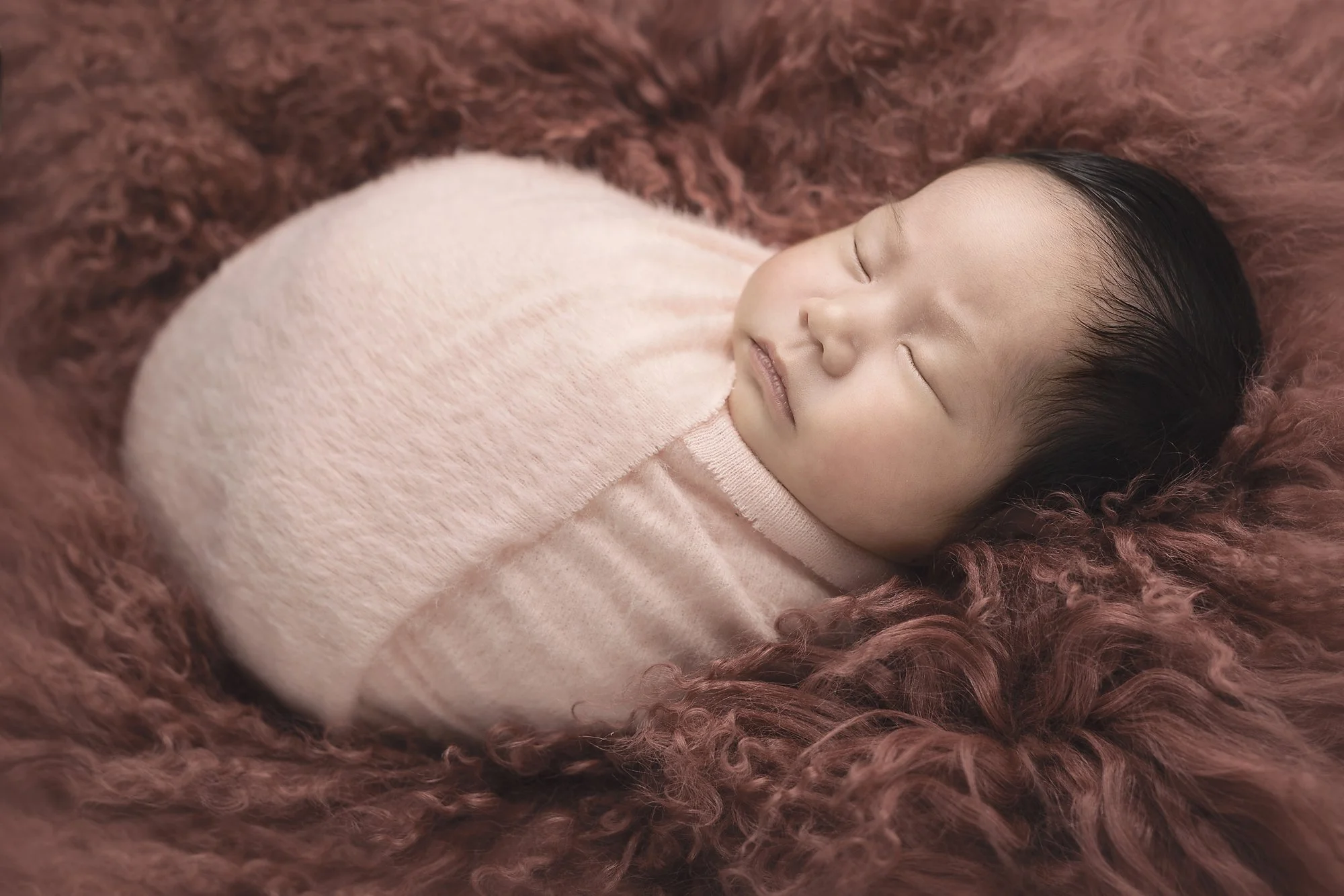 newborn baby girl wrapped in pink asleep on mongolian fur penrith western sydney blue mountains hills district photography