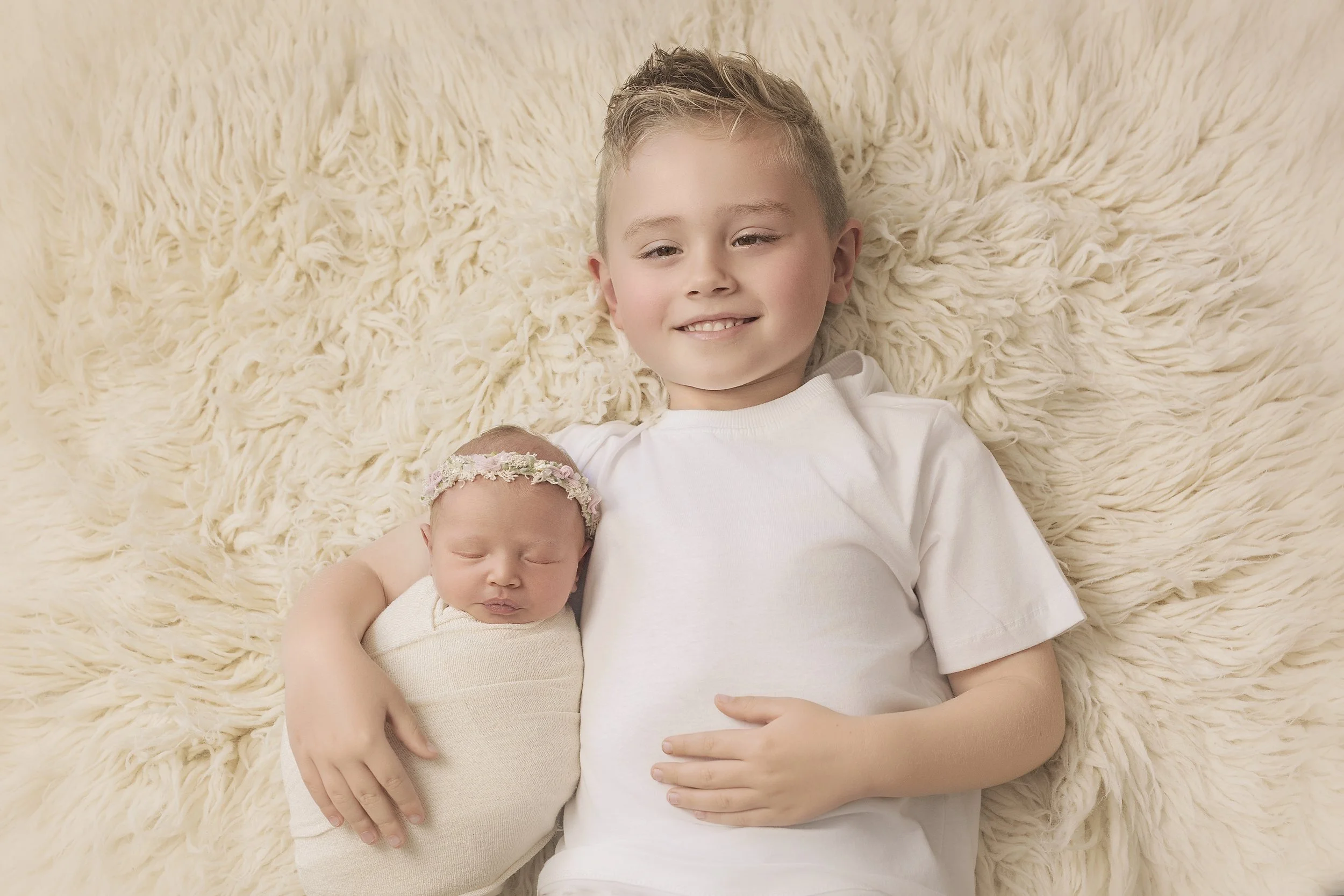 Toddler meeting newborn baby during family photoshoot