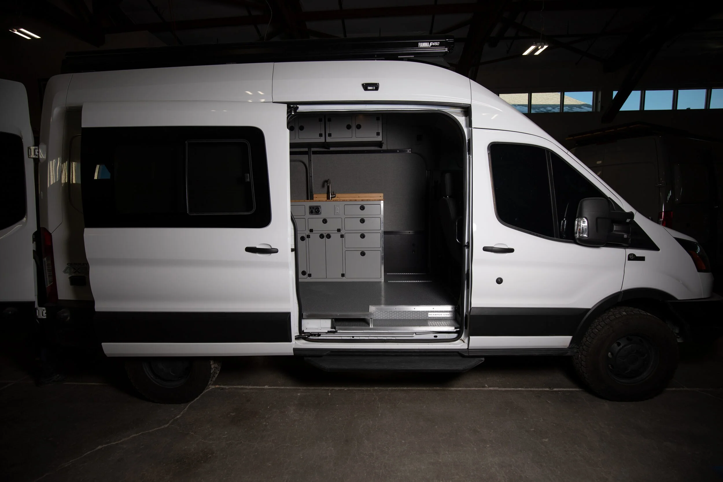 02-transit-148-camper-van-sliding-door-open-cabinets.jpg