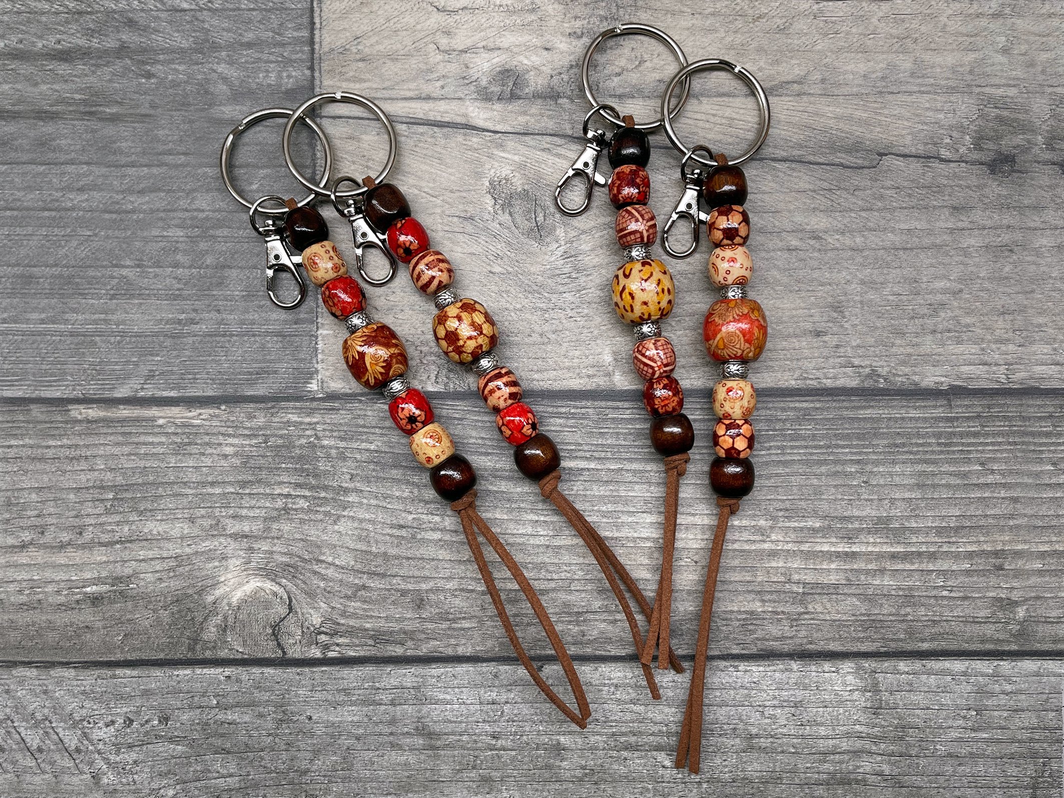 Colorful beaded keychains with leather tassels on wooden background
