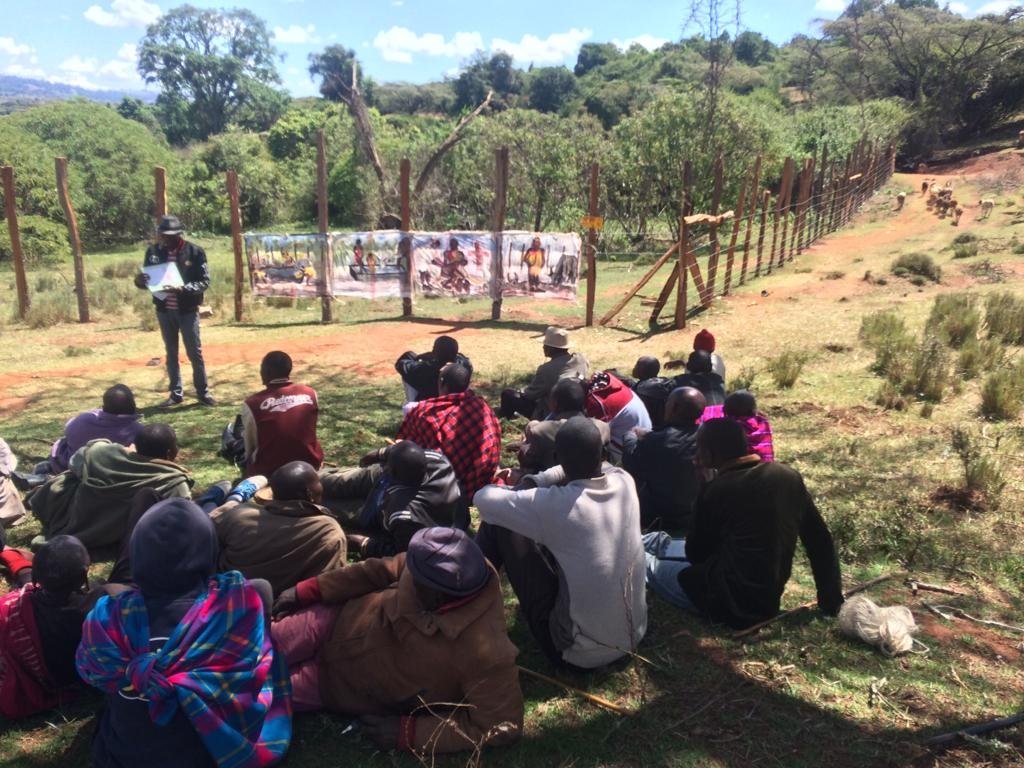 Community meeting discussing the importance of clean water for all - people, elephants, and domestic animals.