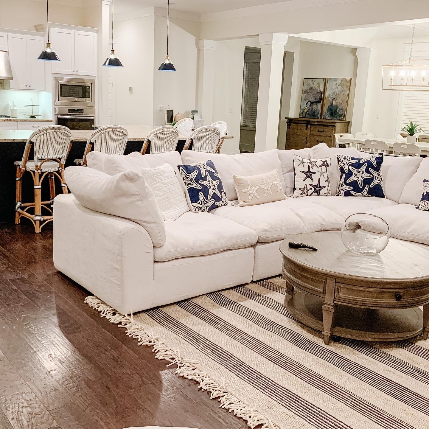 ✨ BEFORE + AFTER ✨ Pt 2
The 30A project transformation continued in the living and kitchen! The dark heavy furniture was replaced with with light toned pieces to create a open feel. Adding pops of navy in the counter stools, pendants and rug for a na