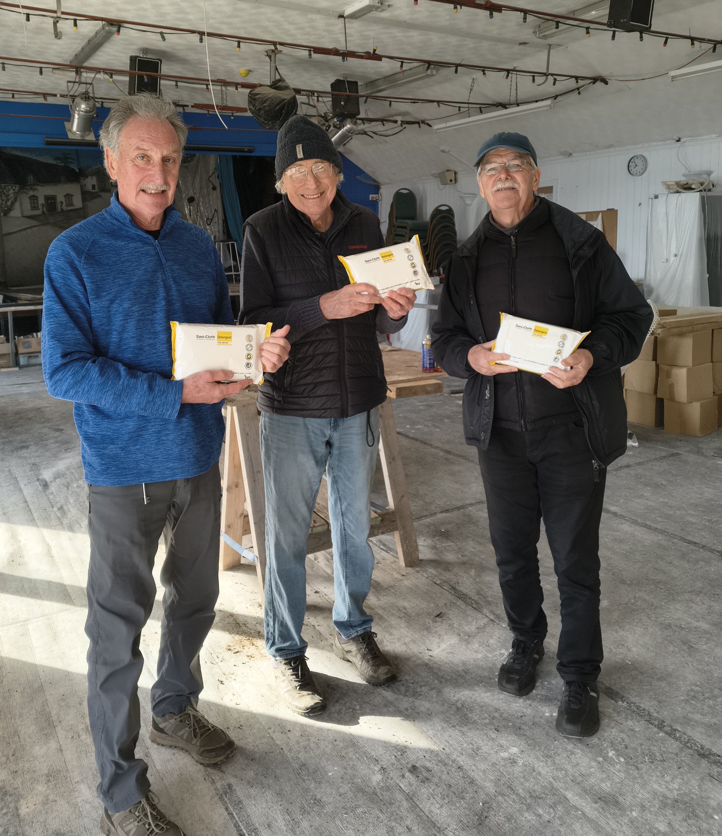 3 people holding detergent wipes