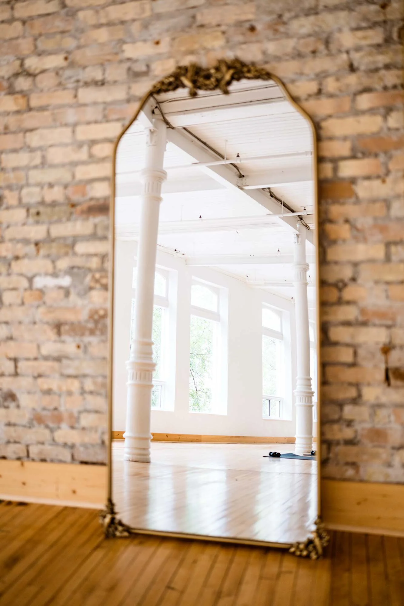 Full-length mirror against exposed brick at 204 Photography's Winnipeg studio, for outfit checks before a professional headshot session.