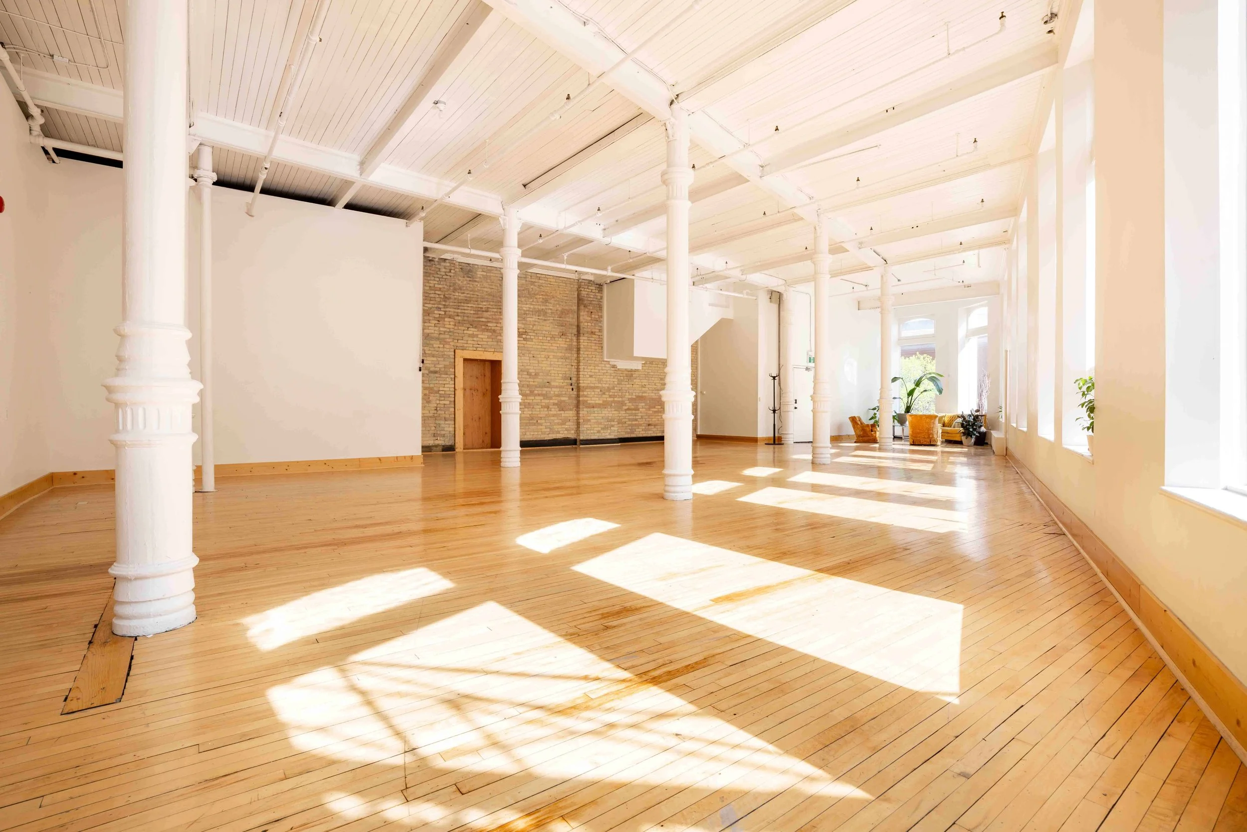 Natural light photo studio with exposed brick and soft daylight — ideal for headshots, content creation, and studio rentals in Winnipeg.