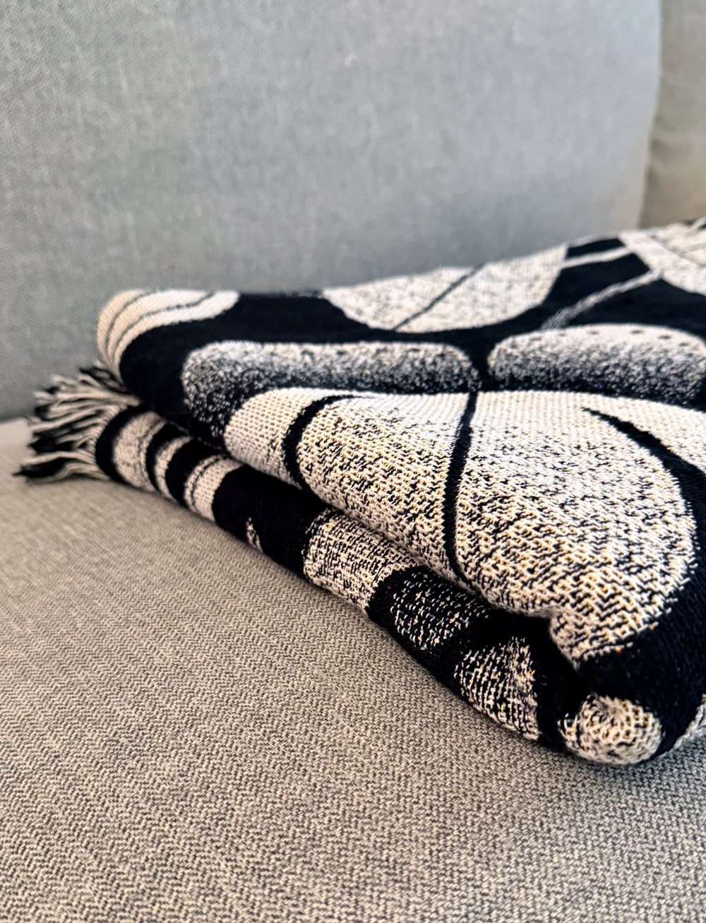 folded woven blanket on grey sofa
