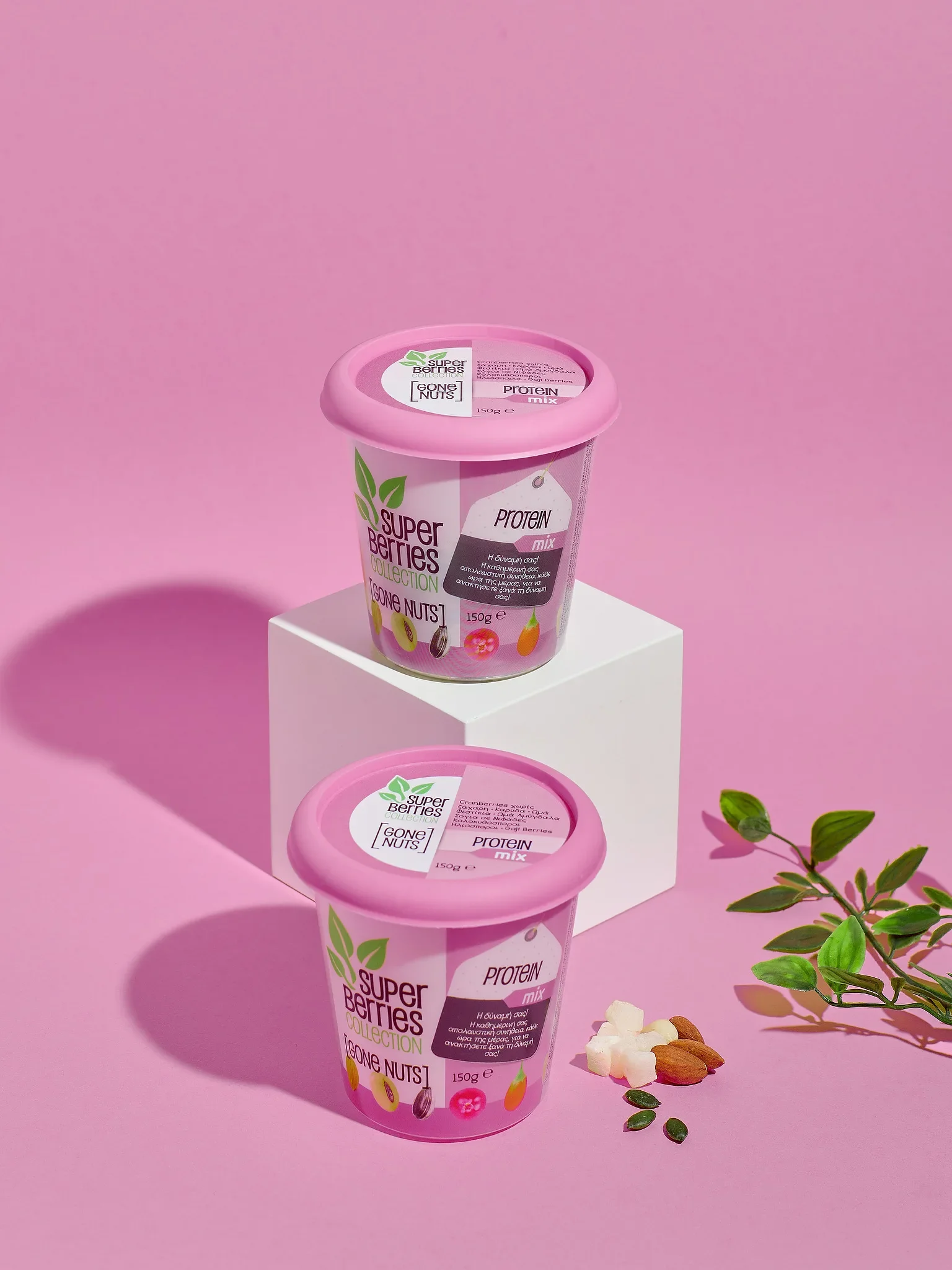 Commercial product photography by Vasilis Geravelis για τη σειρά Super Berries σε ροζ φόντο. Δημιουργική φωτογράφιση συσκευασίας με ξηρούς καρπούς, αμύγδαλα και κύβους προβολής.