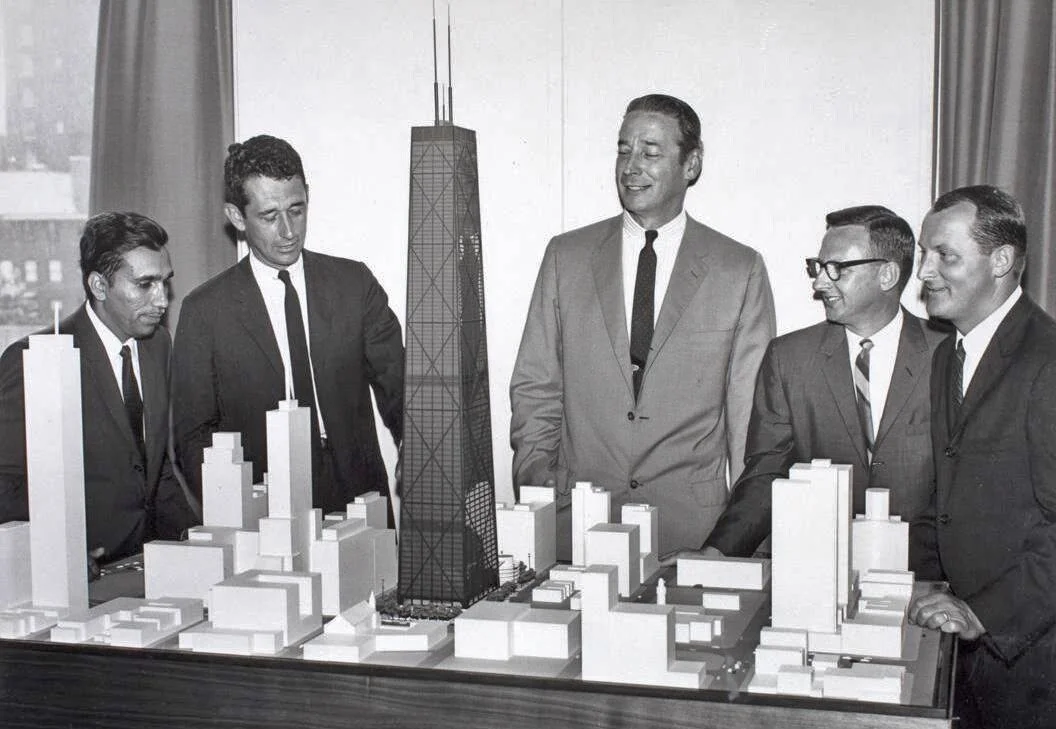 Dr. Fazlur Rahman Khan on the far left, with architect Bruce Graham next to him, at the SOM office in Chicago, with a model of the John Hancock Center, 1960s. Photo Courtesy Skidmore, Owings &amp; Merrill (SOM).
