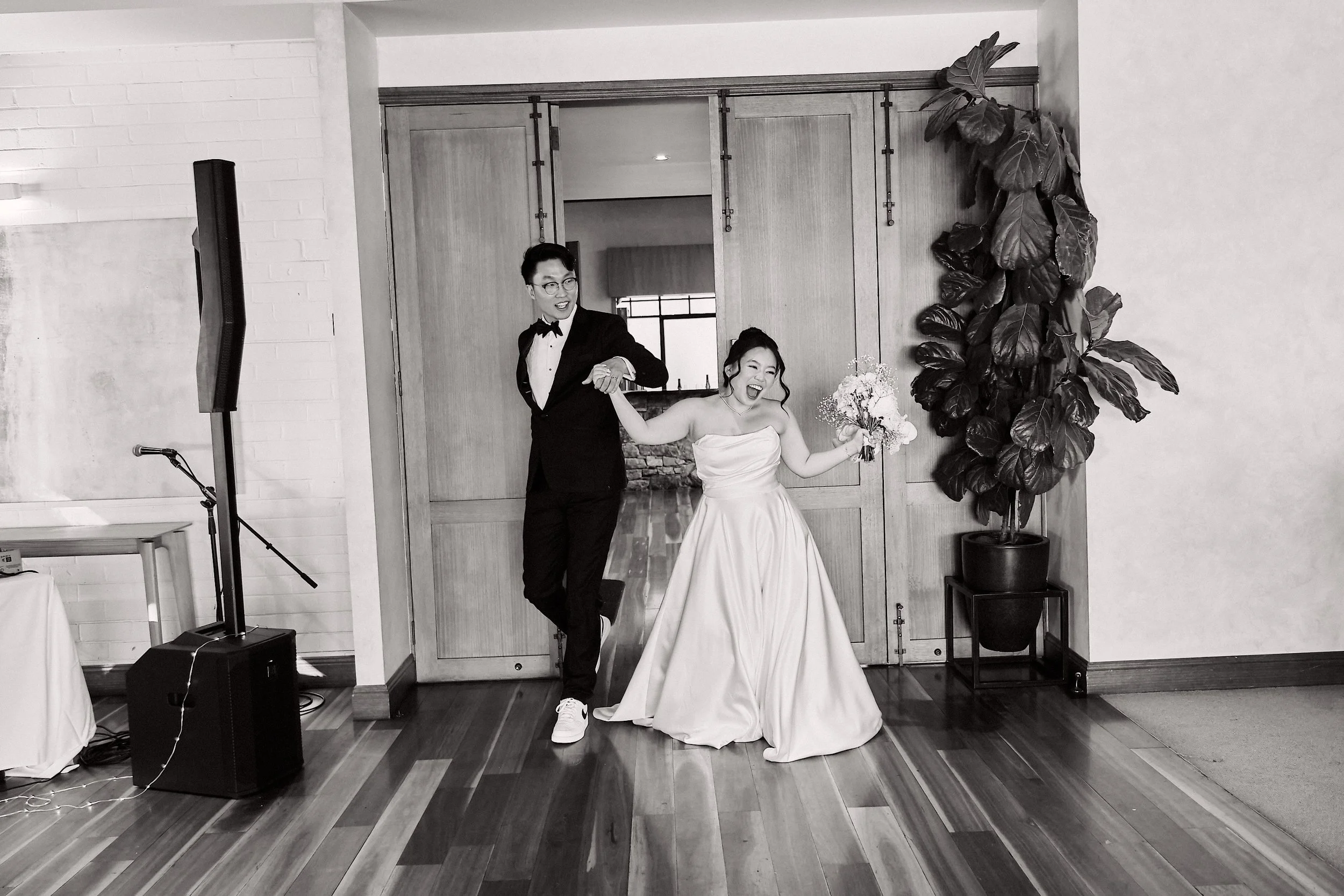 happy bride and groom entering reception