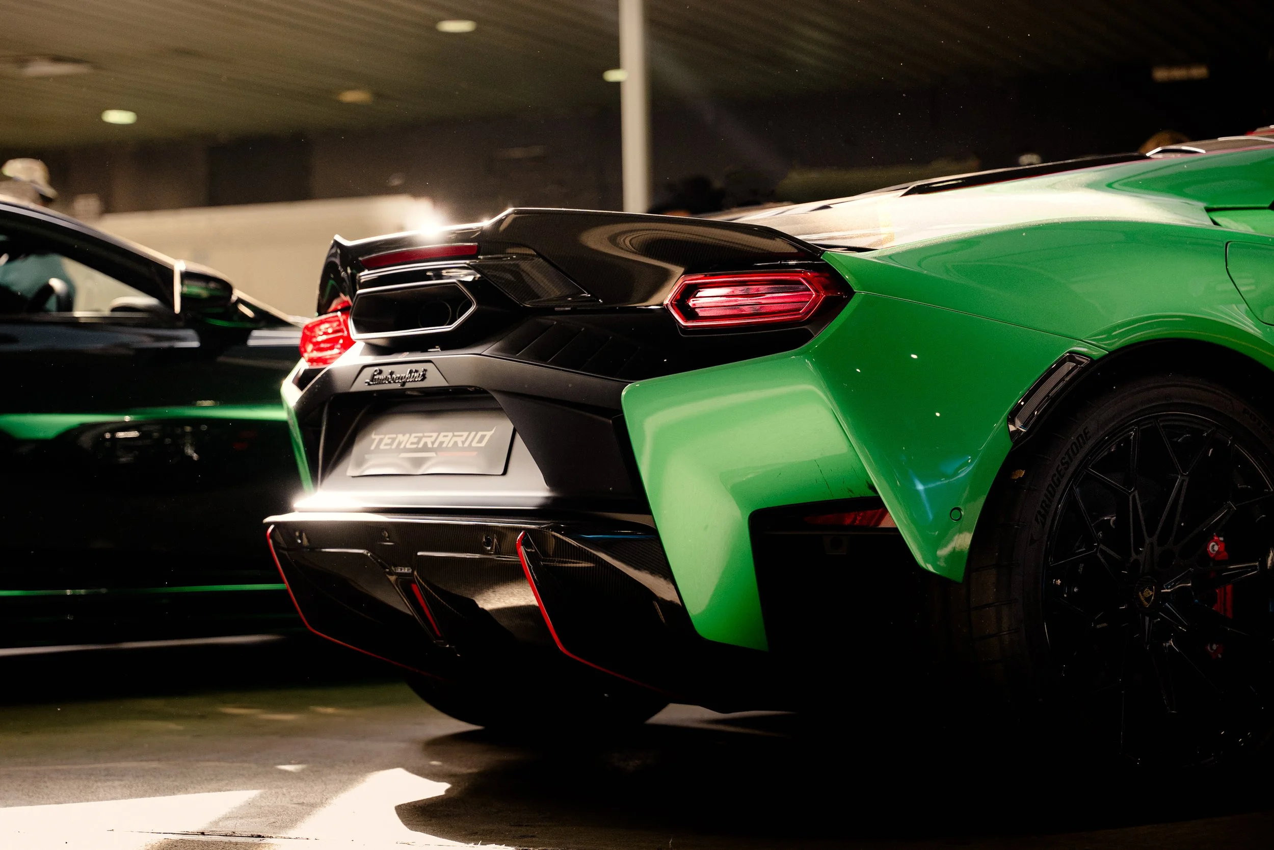 Rear view of a green Lamborghini sports car inside a parking garage.