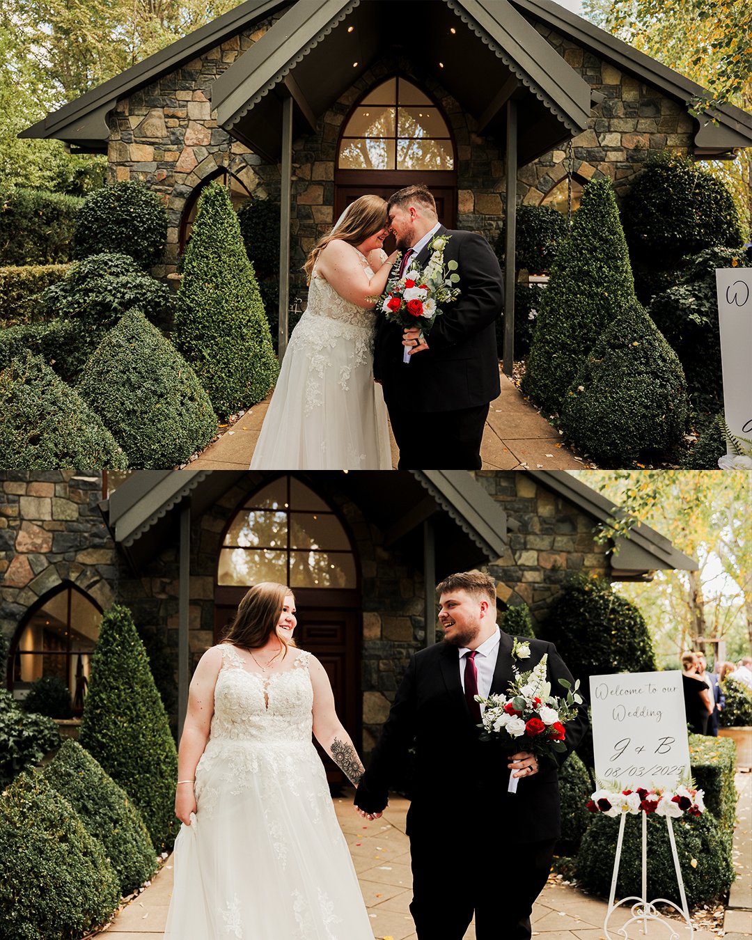 Newlywed couple in wedding attire, the bride in a lace wedding gown and the groom in a black suit, holding a bouquet of red and white flowers, standing in front of a stone chapel, smiling and holding hands, with wedding signage nearby.