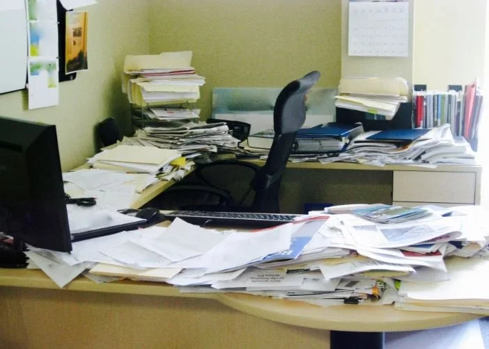 Desk with piles of paper 2.JPG
