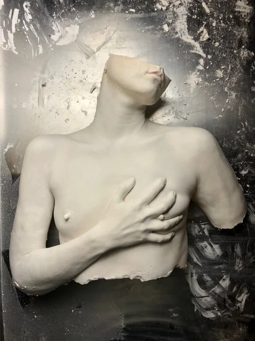 A plaster art cast of a woman clutching her left breast. Erotic Art
