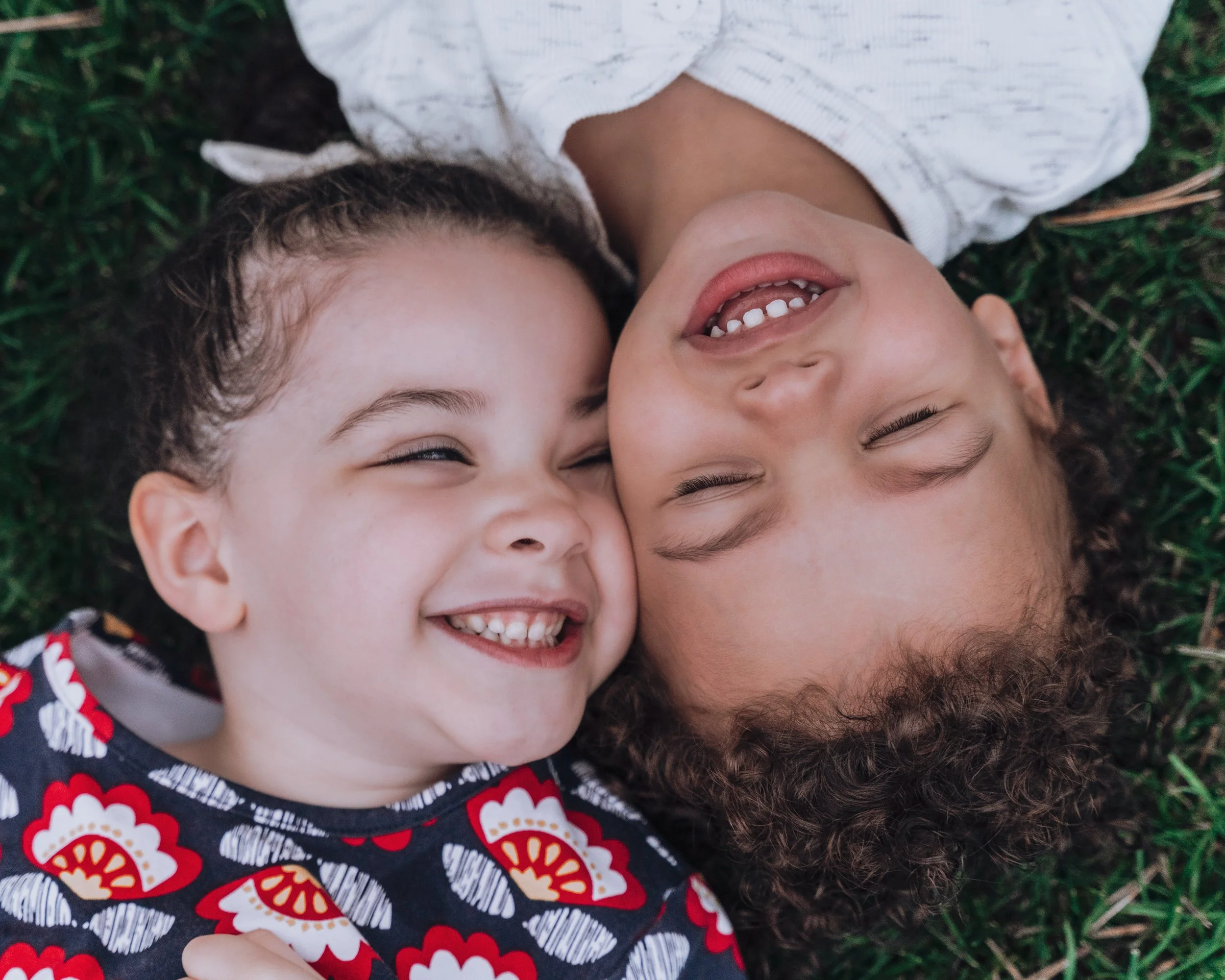 Quinn and Hayes lay head to head in a bed of fresh grass laughing in each other's company at the Lynch Park in Beverly, MA.