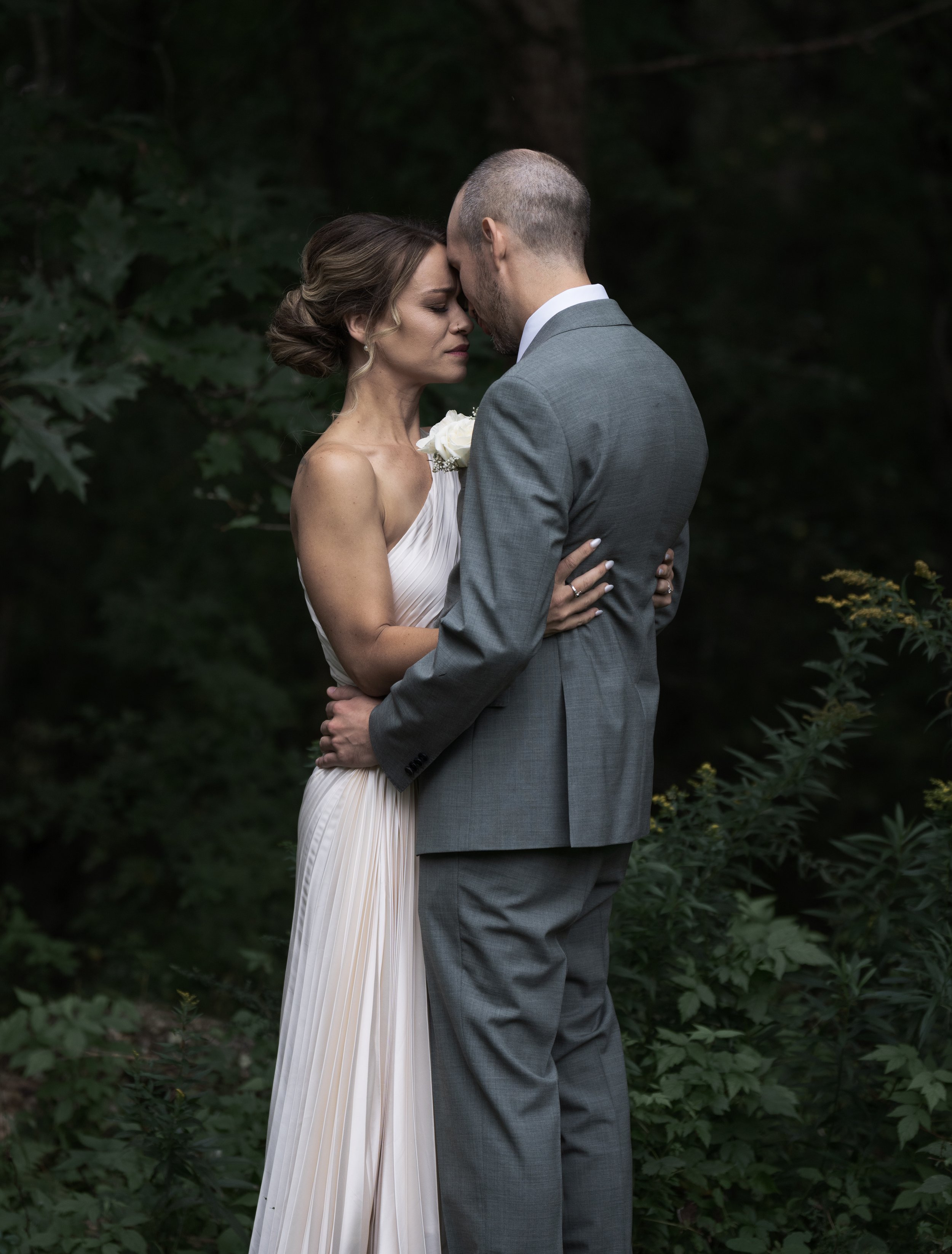 Erin and John take a deep breath with foreheads pressed together, fully soaking in the moment of seeing one another for the first time on their wedding day.