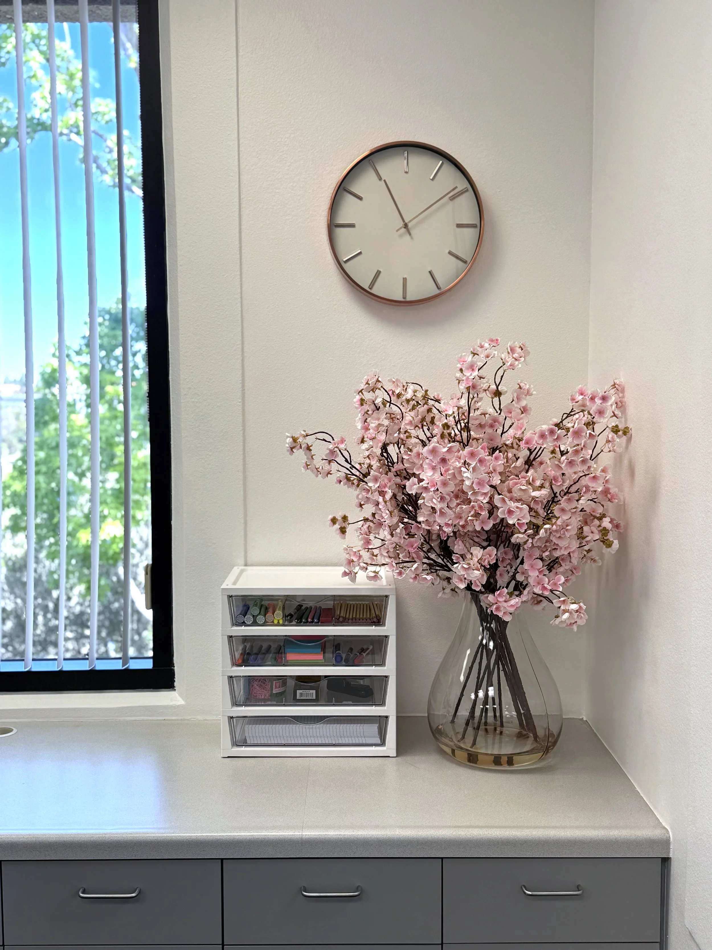 Bright corner of the Eritus Education office featuring fresh cherry blossoms, student resources, and a welcoming space for college counseling sessions