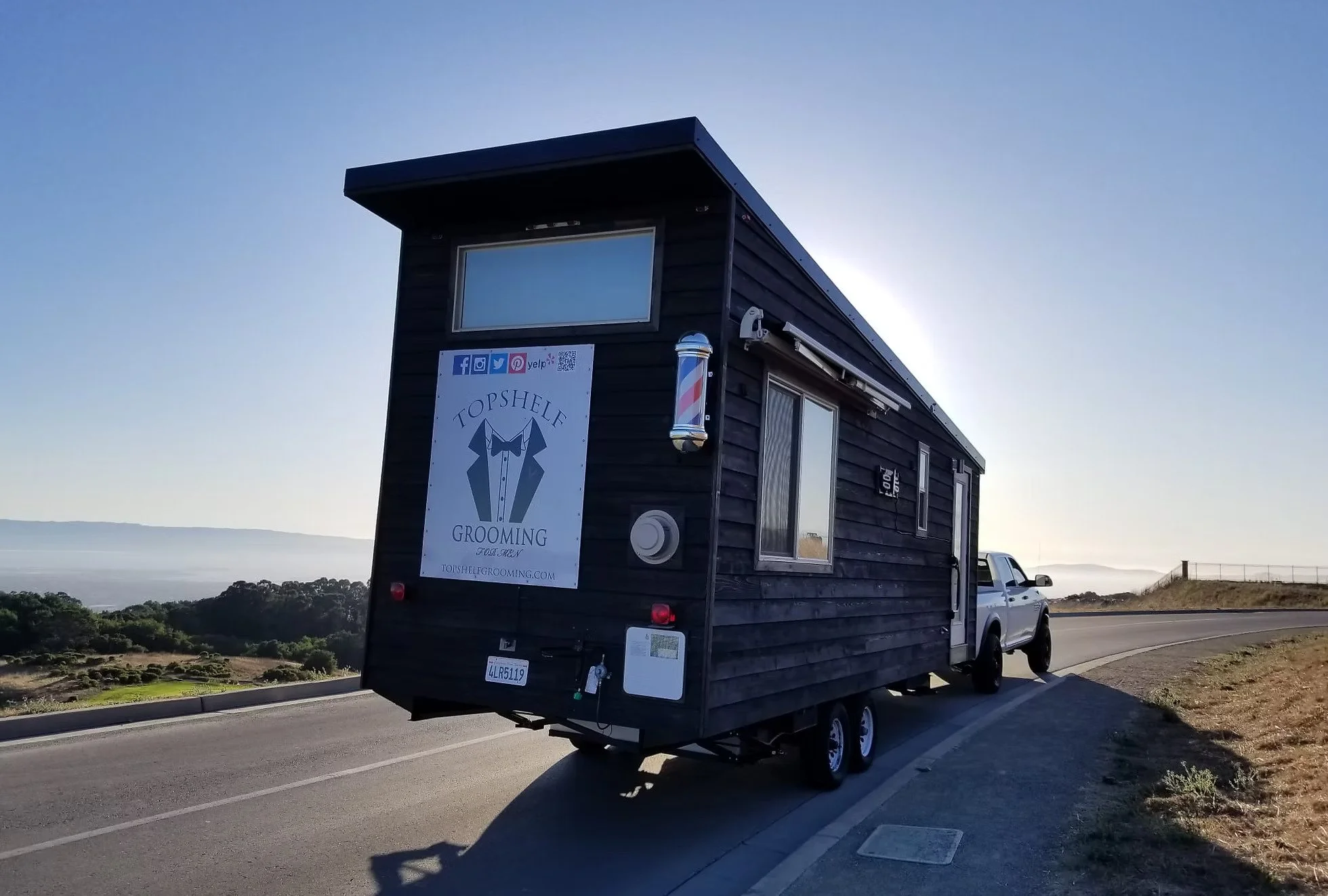 The Topshelf Grooming mobile barbershop trailer parked with a view of the coast, available for on-site wedding and event grooming in the Bay Area, Sacramento, Napa, and Sonoma.