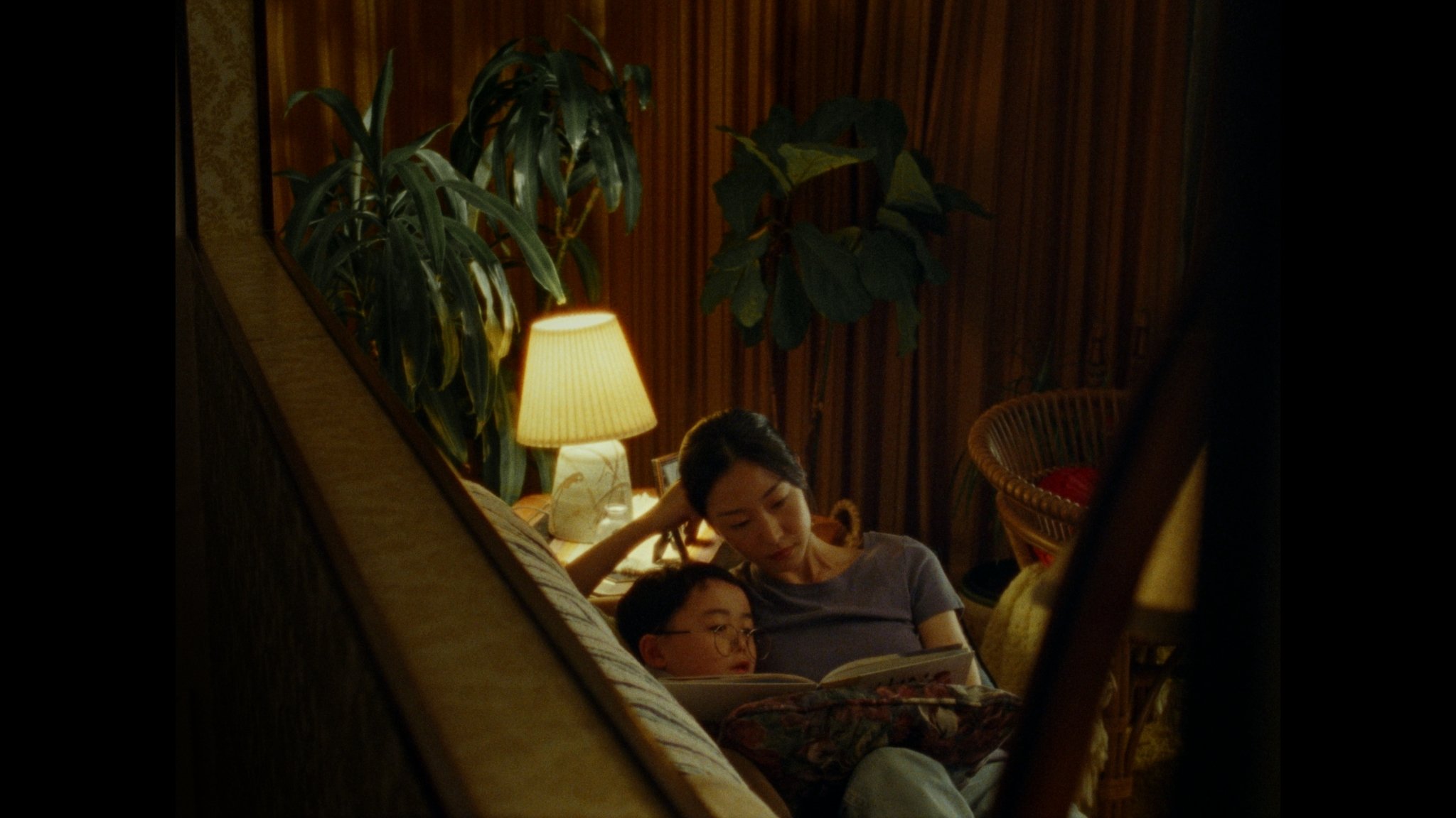 Mom and son sit reading a story on the couch