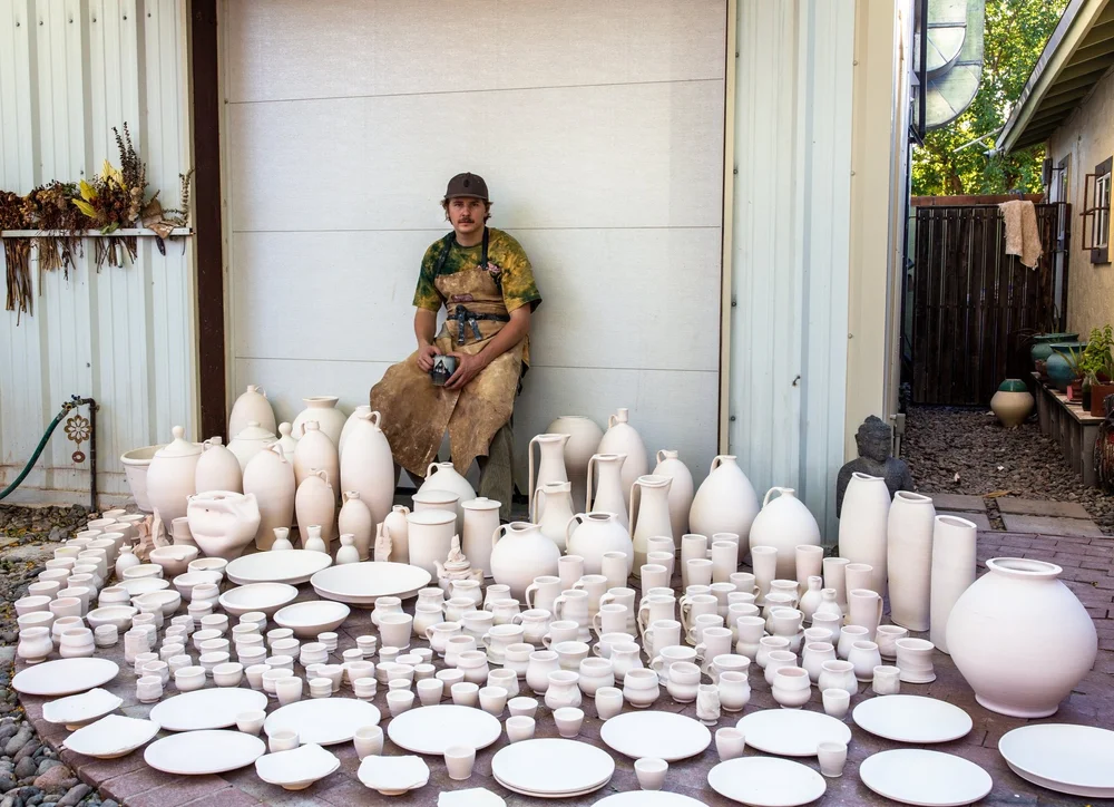 Andrew Smith with rows of ceramic pieces