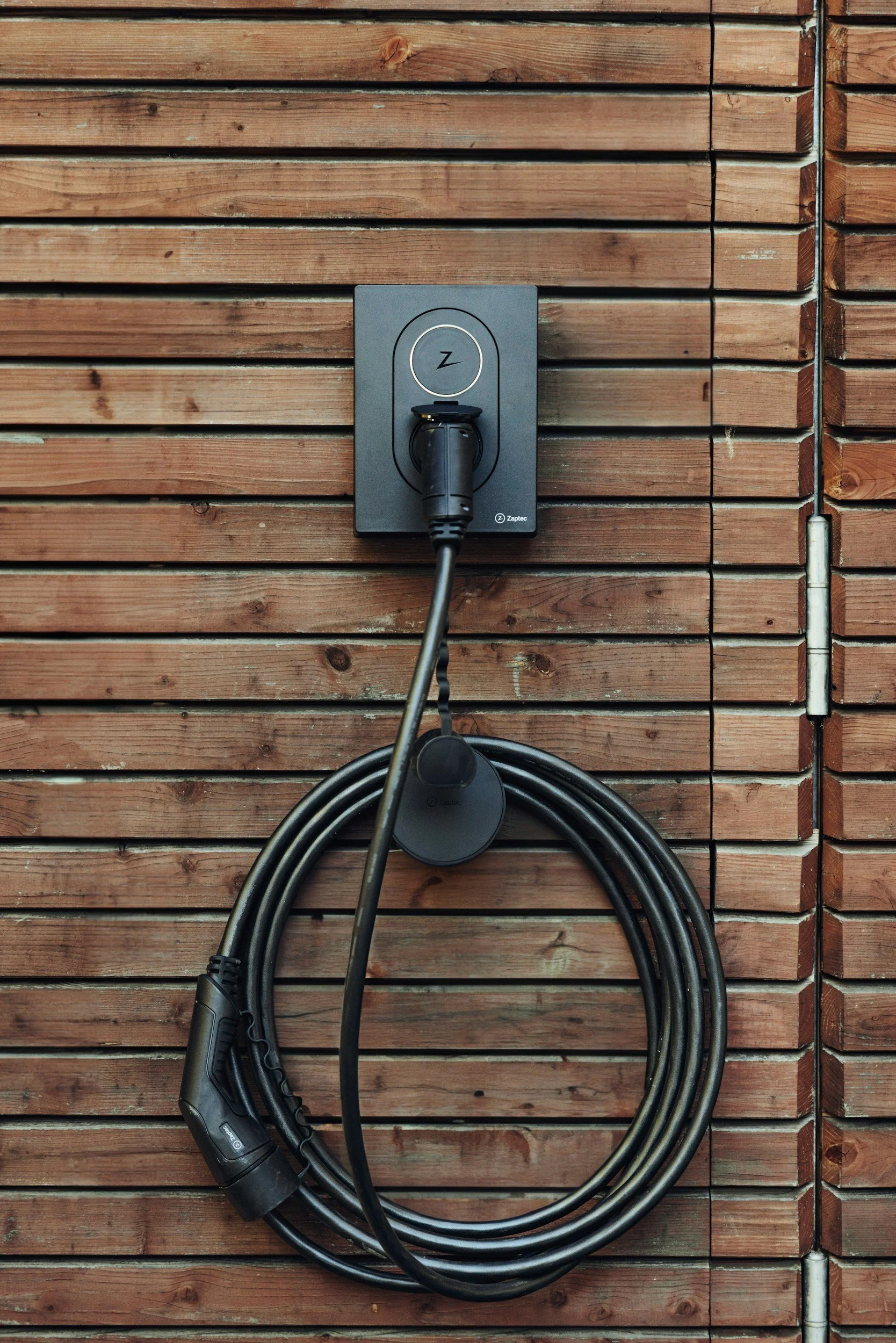 Level 2 EV charger unit mounted on exterior wall of a home for residential charging