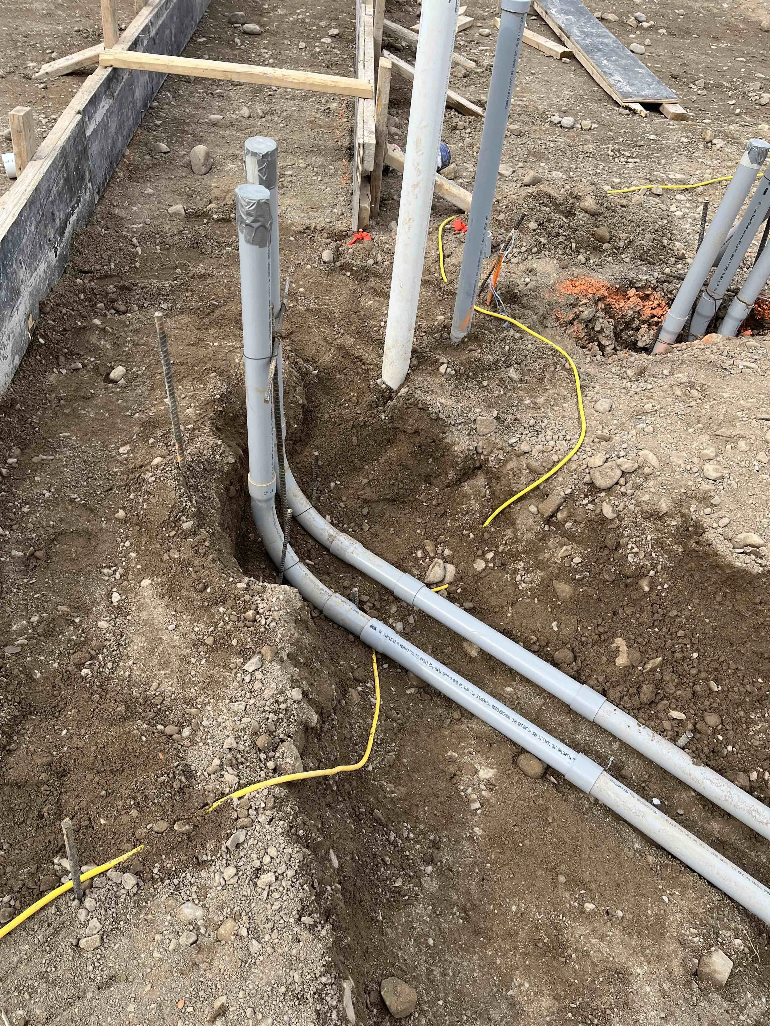 Underground electrical conduit installation during commercial construction site work in Ontario