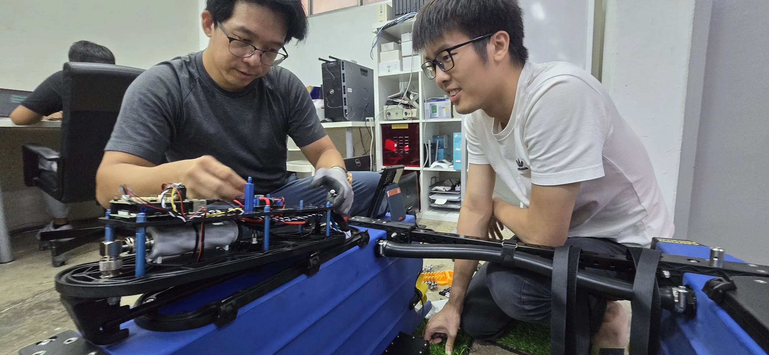 Two colleagues examining electronic components together in a workshop
