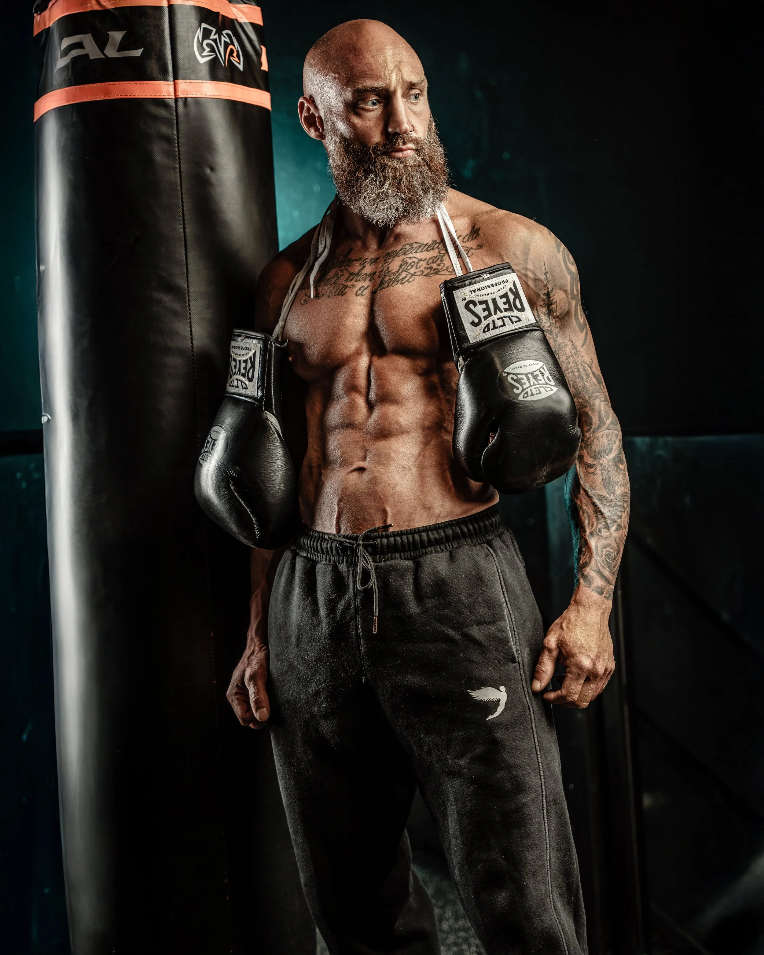 Men with boxing gloves standing near a boxing bag