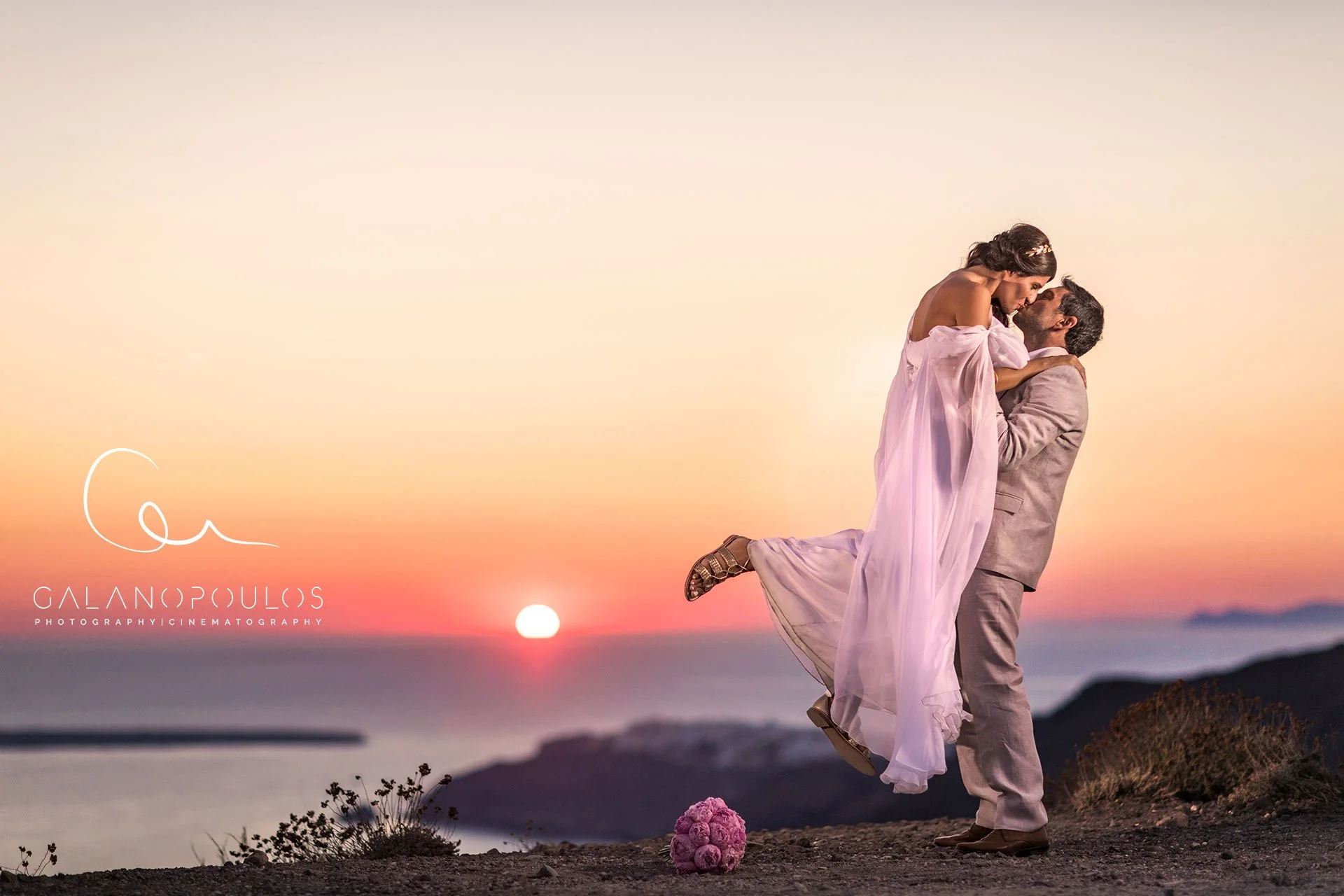 Ammoudi Bay 海邊石階與日落情侶照，海浪、船隻與暖色剪影的浪漫合成；Ammoudi Bay sunset couple portrait — romantic silhouette composition with waves, boats and warm tones.