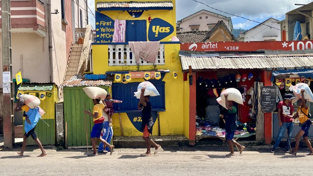 清晨市集布攤與光影：攤販準備上工的靜謐時刻，適合拍攝市集前的準備與氛圍；Sunrise market setup at Ranomafana — vendors preparing stalls in calm morning light, ideal for pre‑market atmosphere shots.