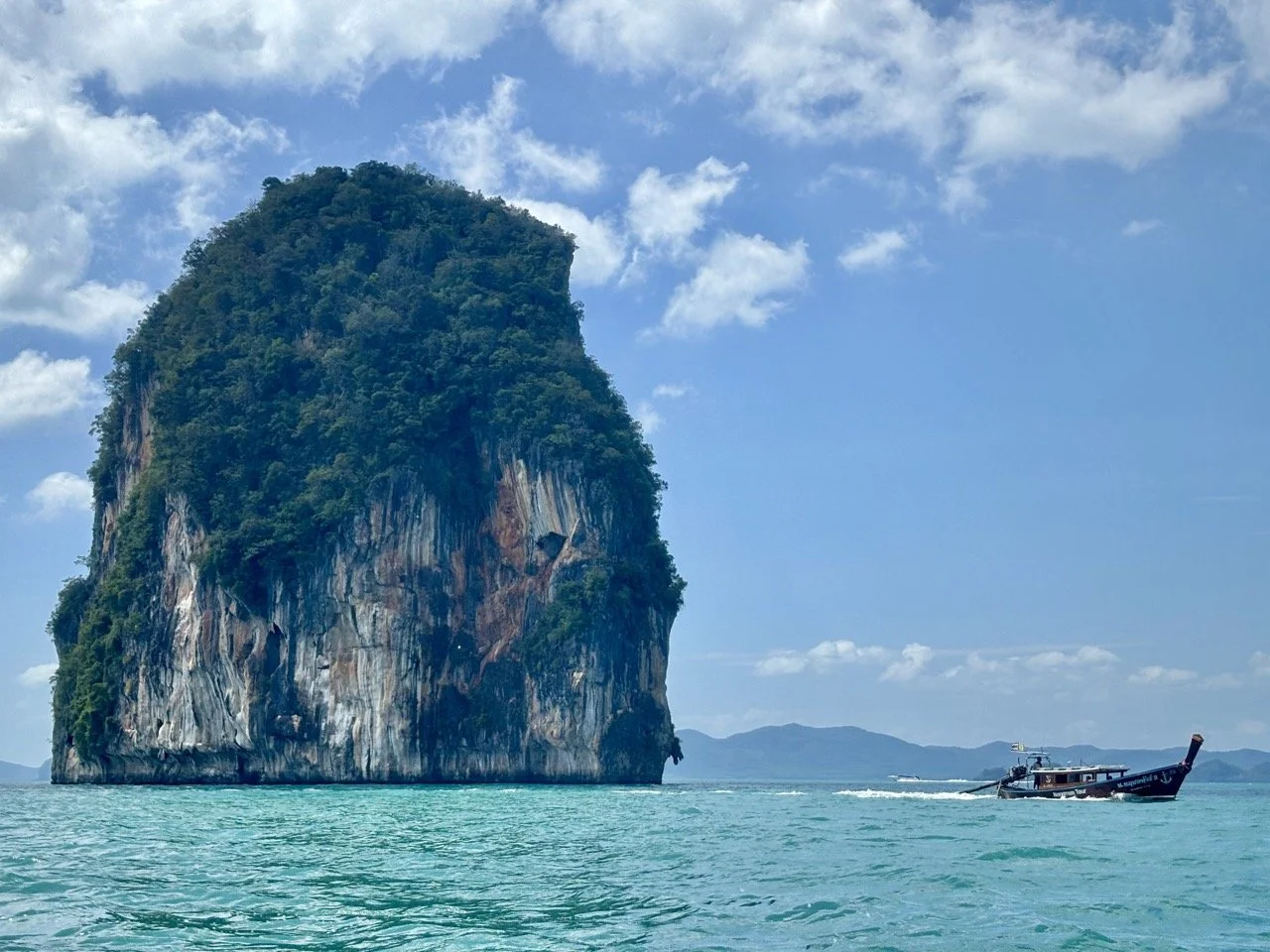 泰國喀比老拉丁島周圍的清澈海水映照陽光與石灰岩海岸，呈現藍綠色的熱帶海島風光，適合介紹 老拉丁島海灘、Hong Islands 跳島行程及喀比清澈海水景點。 Clear turquoise water surrounds Lao Lading Island near Krabi, Thailand, creating a beautiful tropical coastal scene.  複製檔名與 ALT Text