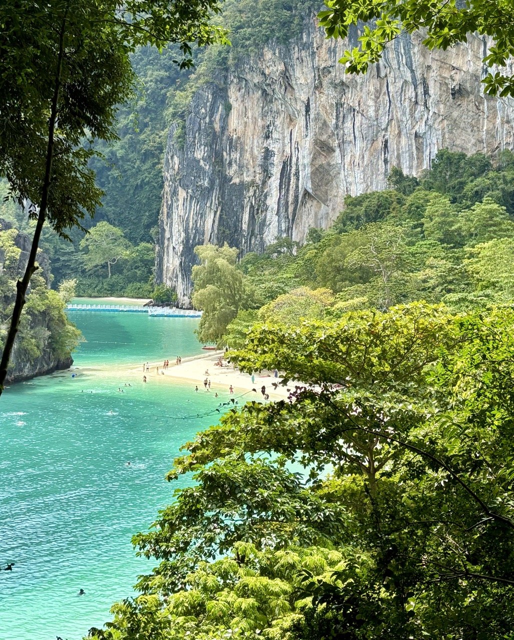 老拉丁島的石灰岩峭壁環繞著小巧的沙灘，展現泰國喀比洪島群島獨特的熱帶地形，是搜尋 Lao Lading Island beach、喀比石灰岩島嶼與泰國秘境沙灘 的旅客值得收藏的自然景色。 Limestone cliffs surround the sandy beach of Lao Lading Island, a scenic stop on tours near Krabi, Thailand.  複製檔名與 ALT Text