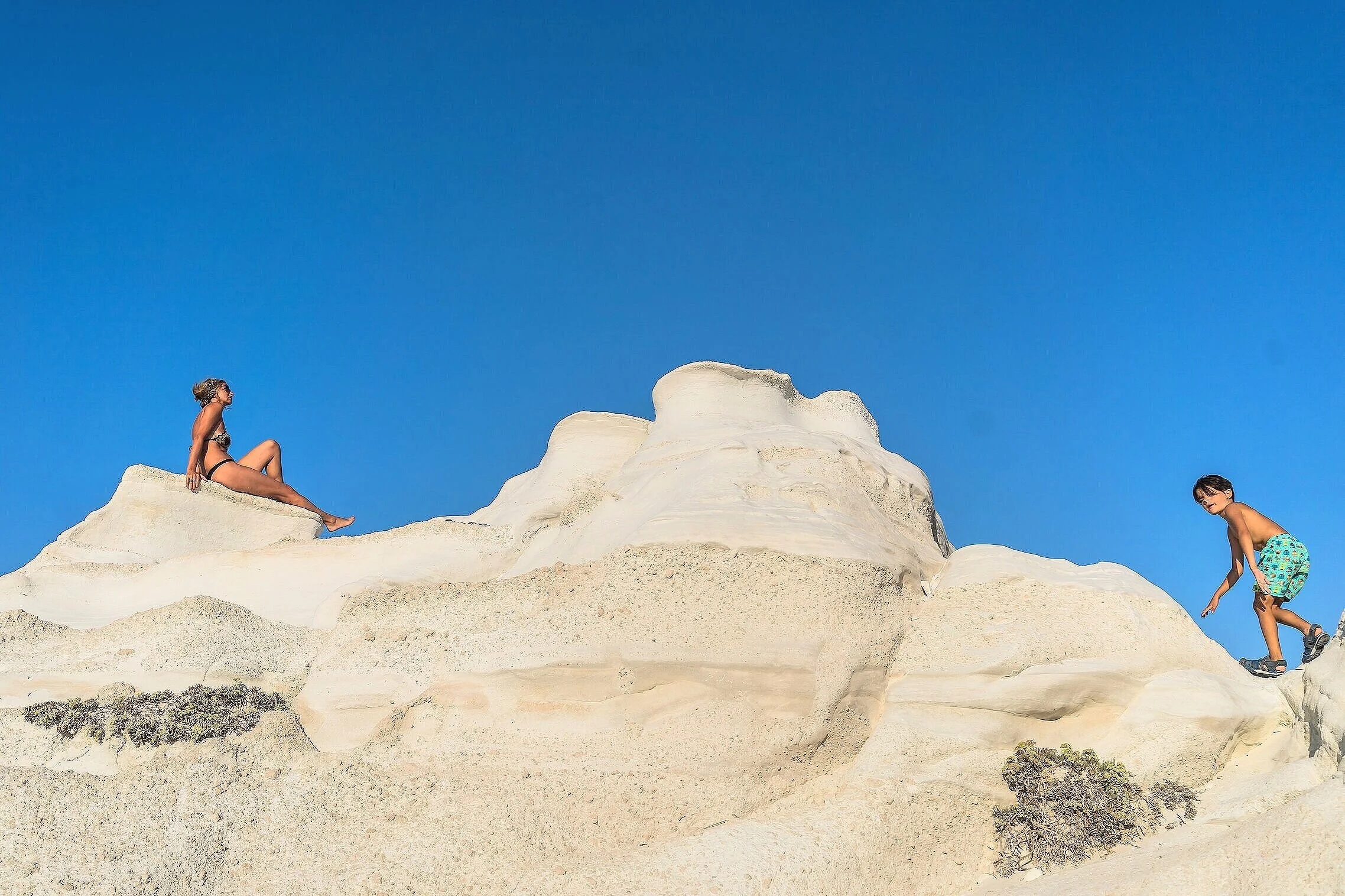 ミロス島（Milos）トラベルガイド用画像：エメラルドグリーンの海と海蝕洞（シーケーブ）、風化した海岸線が織りなす絶景。ゴールデンアワーの撮影スポット、人気ビーチ（フィロス・サルタラなど）、ボートツアー情報やフォトジェニックな構図を想起させ、ビーチ巡りや海蝕洞撮影を計画する旅行者に最適な参照画像です。