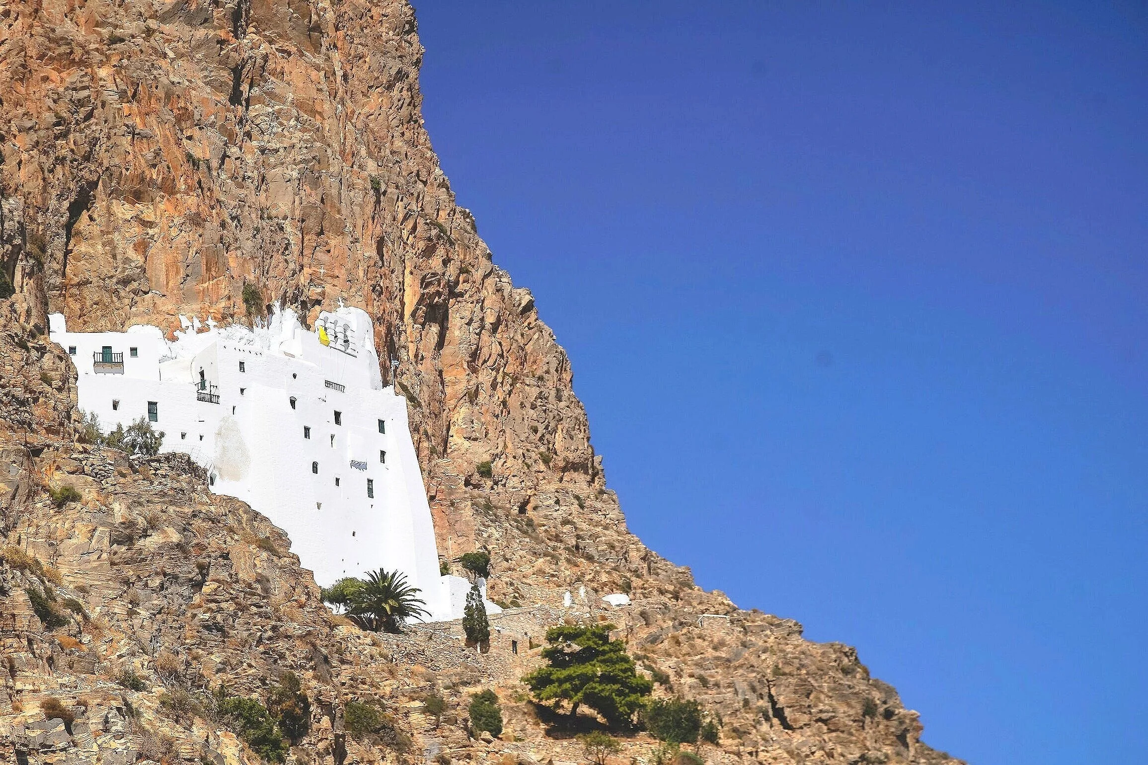 아모르고스(Amorgos) 여행 가이드 이미지: 절벽 위 수도원과 전통 흰색 마을, 투명한 에게해 해변이 어우러진 장면으로 아모르고스의 필수 방문 명소와 숨겨진 포토스팟을 보여줍니다. 골든아워 촬영 포인트, 수도원(호라·호라 수도원)과 절벽 산책로, 페리 접근성 및 인스타그램용 구도를 연상시키는 비주얼로 아모르고스 사진여행과 문화체험을 계획하는 여행자에게 최적화된 이미지입니다.