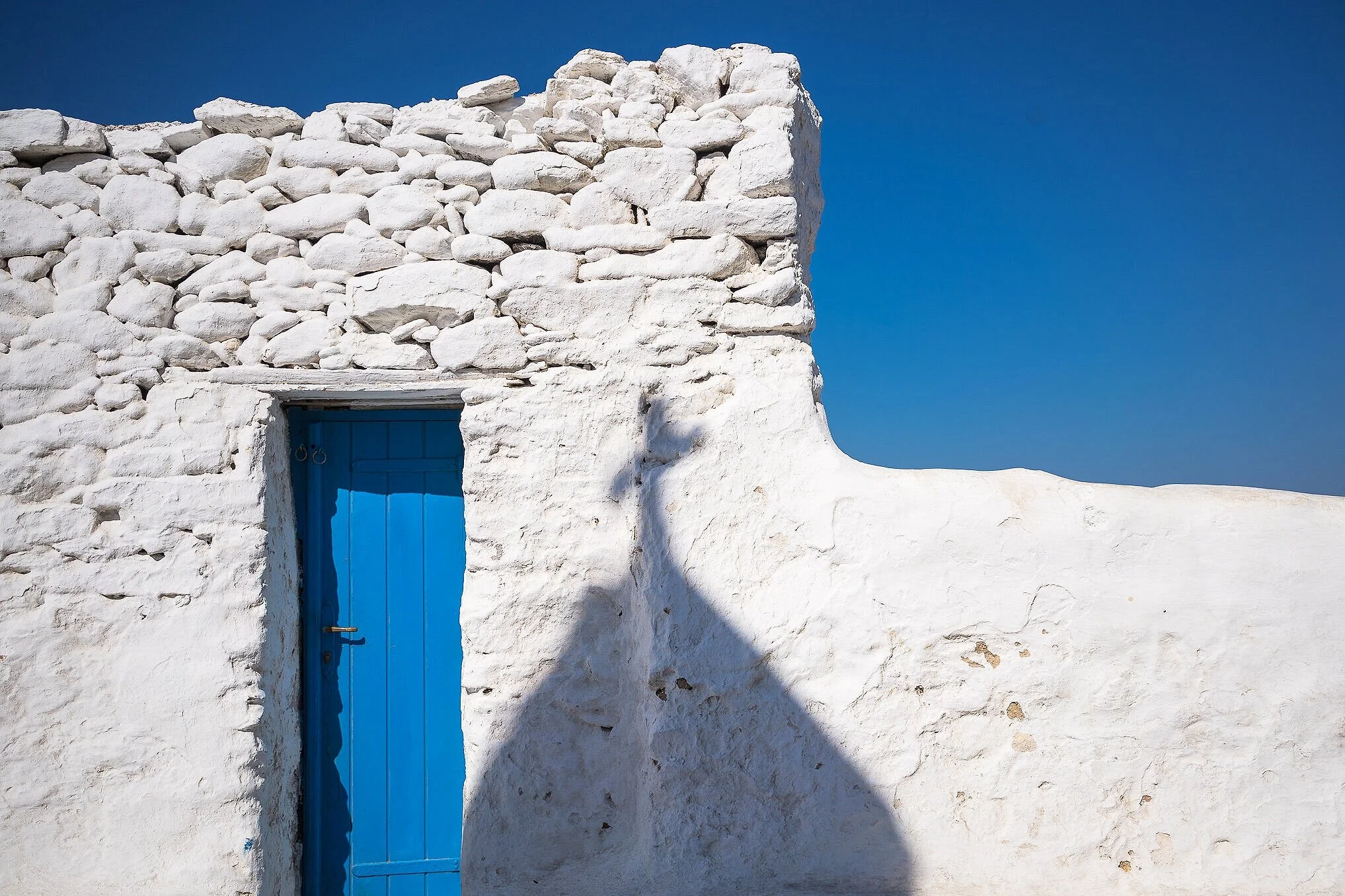 미코노스(Mykonos) 여행 가이드 이미지: 상징적인 풍차(윈드밀)와 에메랄드빛 해변, 좁은 흰색 골목의 포토제닉 장면을 골든아워에 담아 미코노스의 베스트 사진 스팟(파라다이스 비치·플라카·리틀베니스 등)과 해변·야경 촬영 포인트, 페리 접근 및 인스타그램용 구도를 떠올리게 하는 비주얼입니다.