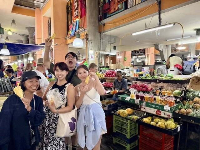 小團體私旅導覽實況，導遊與旅客在路邊試吃 Dholl Puri 與分享歷史故事的互動畫面。