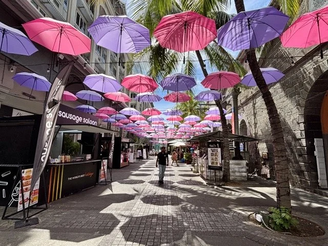Port Louis 巷弄街頭藝術壁畫與當地居民生活互動，私藏攝影景點推介。 Street art murals in Port Louis alleys interacting with local life—a recommended hidden photography spot.