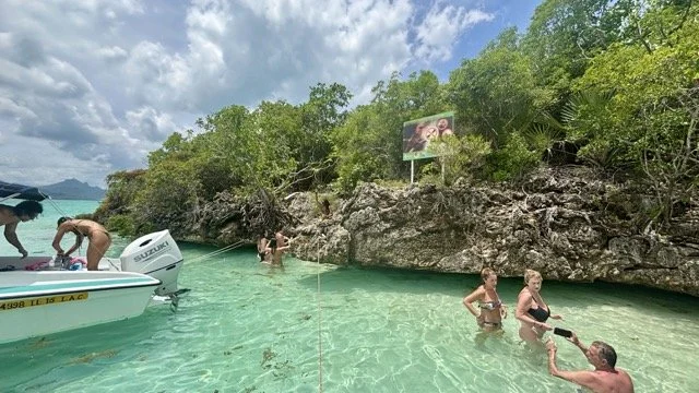 杜斯水灣五島跳島行的觀光船在海上繞行，多個小島點綴海平面，是 island hopping 航程全景示意圖。