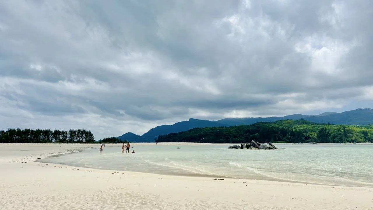 塞席爾離島沙洲上的旅客在淺水區游泳，享受馬埃島一日遊清澈海水與陽光充足的海島度假時光。