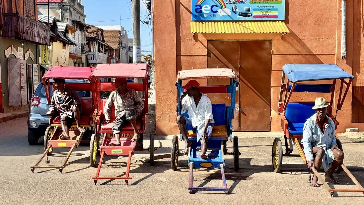 熱鬧市集通道景象：買賣來回的人潮、聊天與交換物品的生活片段；Busy market aisles in Ranomafana — shoppers, conversations and the lively exchange of goods.