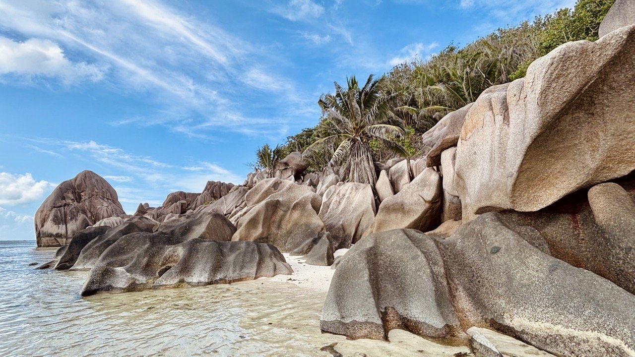 塞席爾拉迪格島 Petite Anse Beach，寧靜沙灘、深色花崗岩與印度洋海浪呈現原始自然風貌。