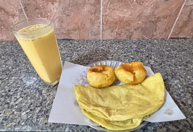 模里西斯攤販多樣配菜展示，包含 Atchar 酸辣腌菜與 Rougaille 番茄醬，搭配 Dholl Puri 味道層次。 Display of local condiments at a Mauritius stall including Atchar pickles and Rougaille sauce, pairing with Dholl Puri.