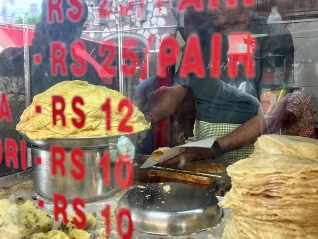 攤販現場製作 Dholl Puri 豆餅卷過程，揉麵、包餡與熱鍋煎製的街頭美食紀實。 Street vendor making Dholl Puri by hand—dough pressing, filling with split peas and griddle cooking in Mauritius.